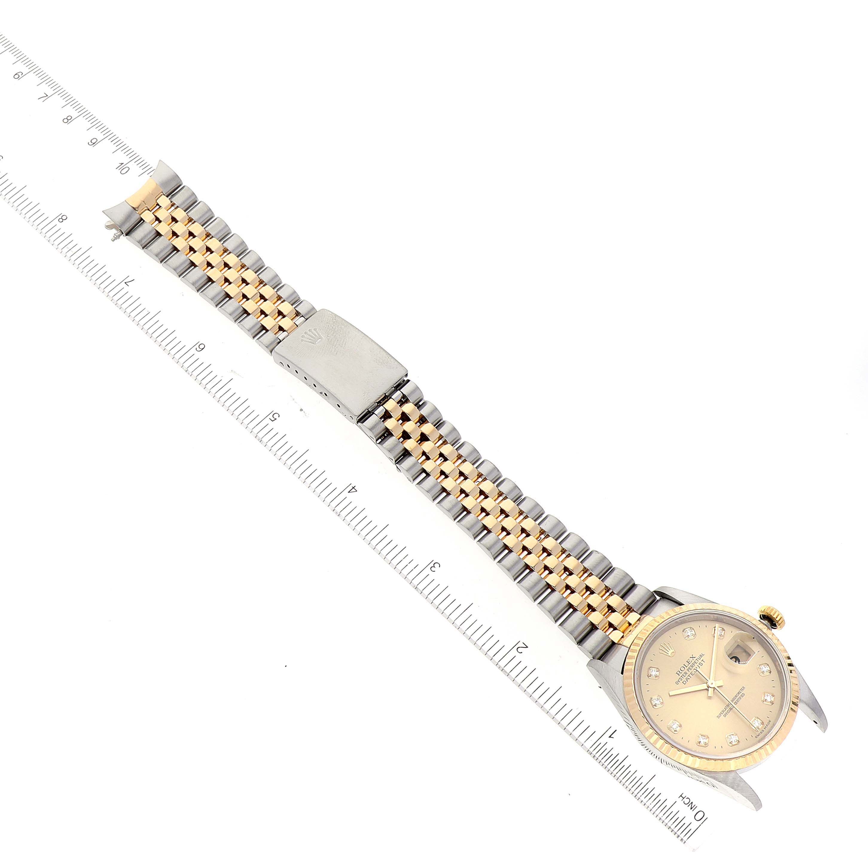 This image shows a Rolex Datejust 16233 Men's Steel and Gold (two tone) Champagne Dial 16233 Men's Steel and Gold (two tone) Champagne Dial watch laid flat, displaying the dial, jubilee bracelet, and clasp with a ruler for scale.