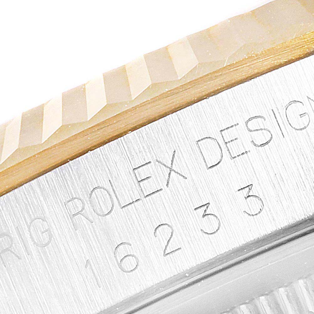This close-up image of a Rolex Datejust 16233 Men's Steel and Gold (two tone) White Dial 16233 Men's Steel and Gold (two tone) White Dial watch shows part of the bezel and the engraved model number.
