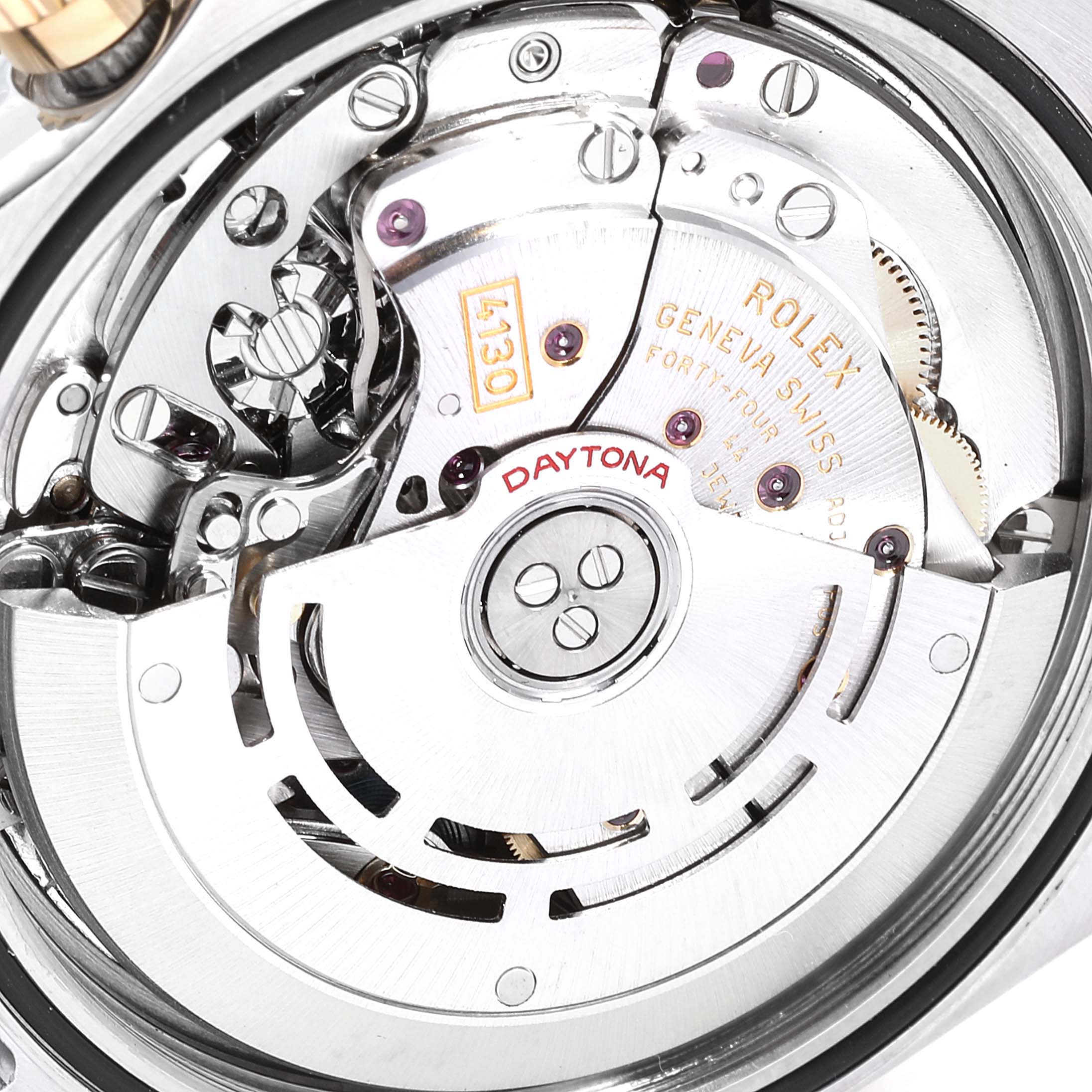 The image shows a close-up of the movement mechanism of a Rolex Daytona 116523 Men
s Steel and Gold (two tone) Black Dial 116523 Men
s Steel and Gold (two tone) Black Dial watch, displaying intricate gears and engravings.