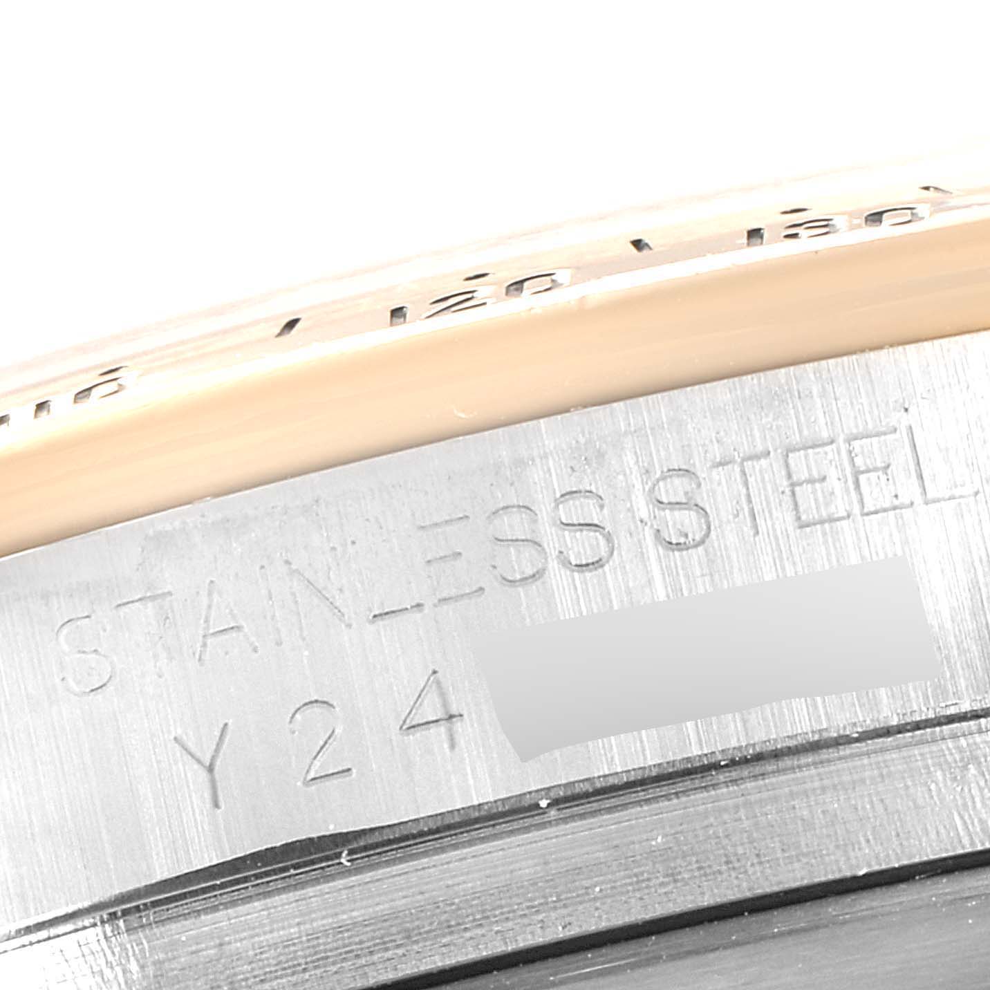 The image shows a close-up of the case back edge of a Rolex Daytona 116523 Men
s Steel and Gold (two tone) Black Dial 116523 Men
s Steel and Gold (two tone) Black Dial, highlighting the stainless steel material and part of the serial number.