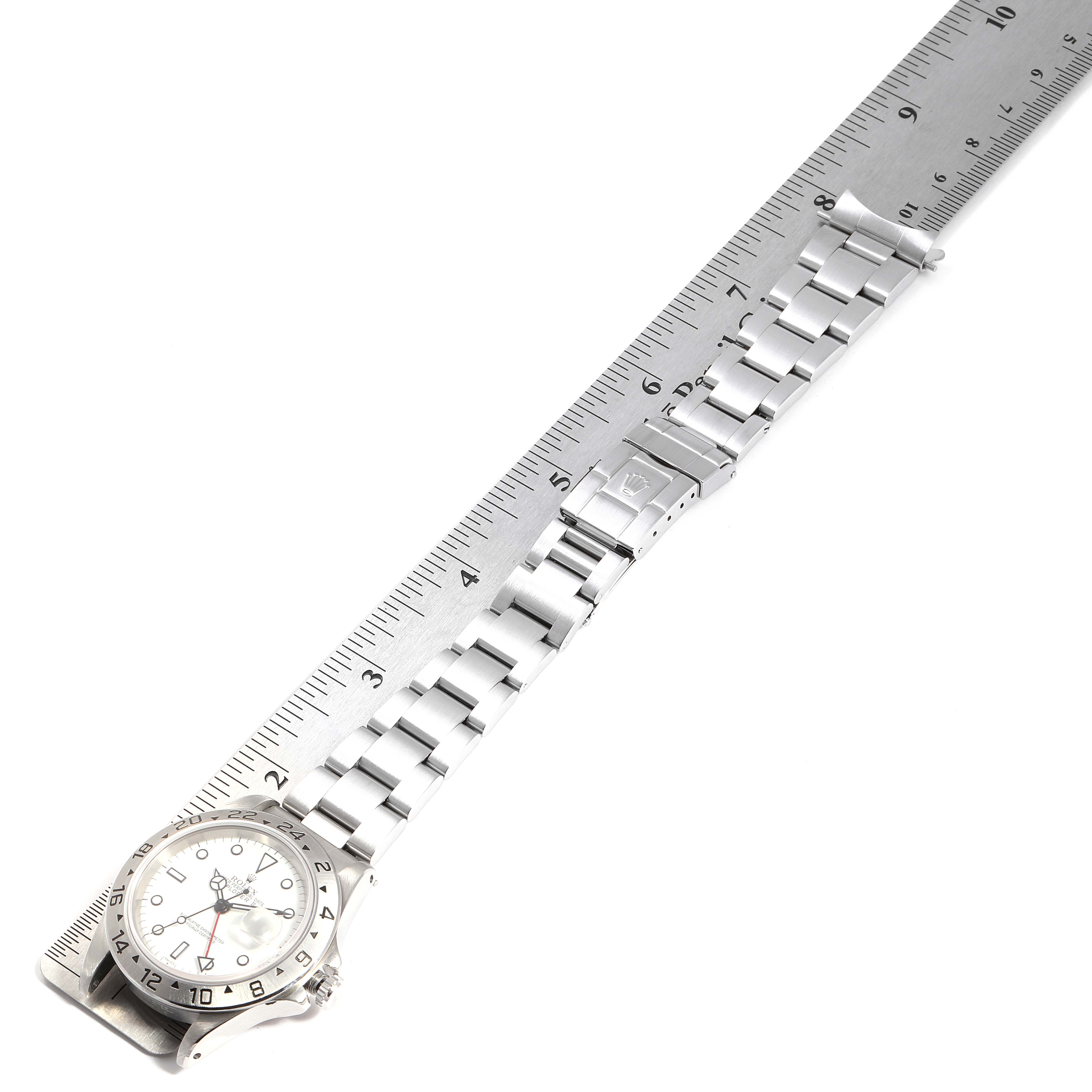 The image shows a ruler alongside a Rolex Explorer 16570 Men
s Stainless Steel White Dial 16570 Men
s Stainless Steel White Dial model, displaying its full length including the watch face and metal bracelet.