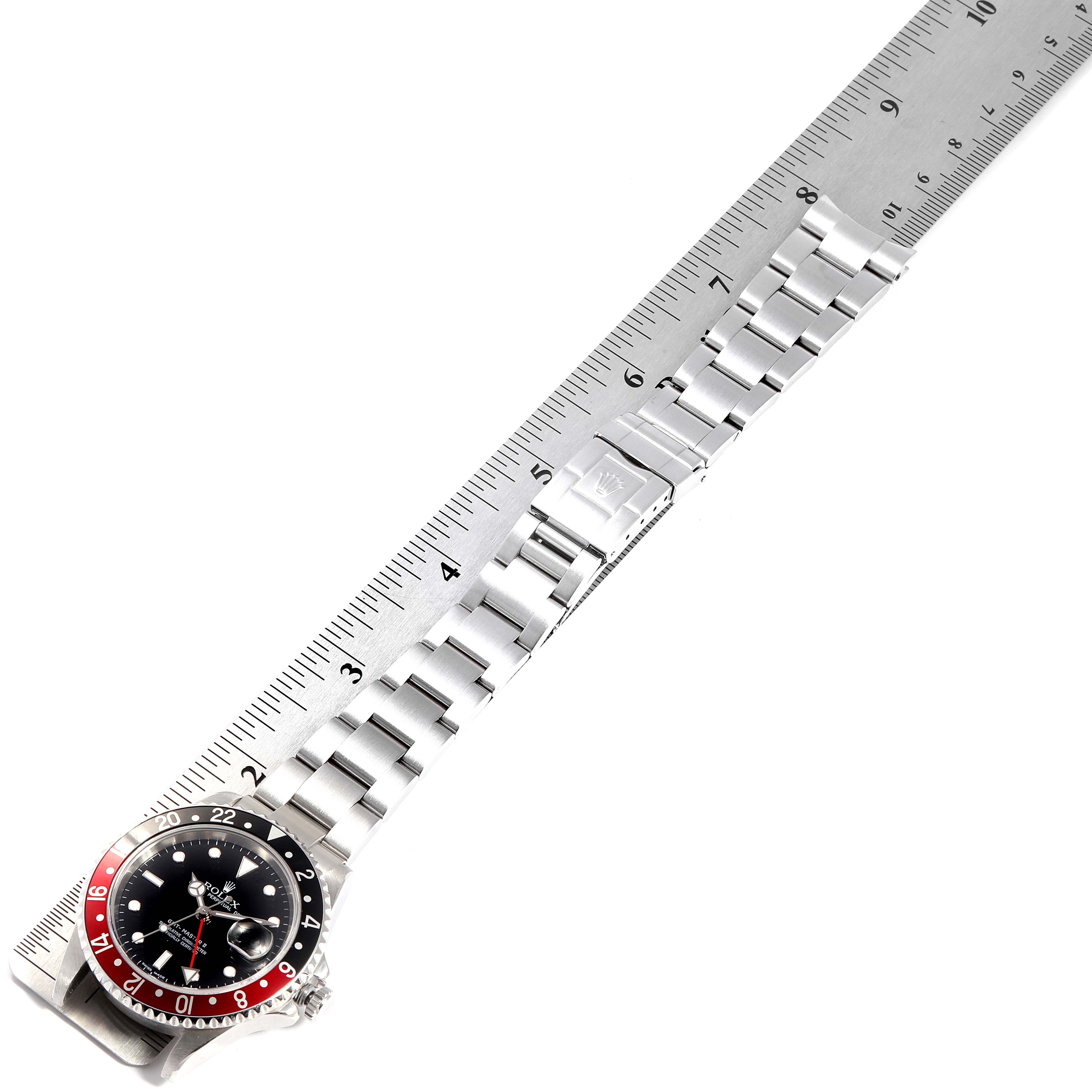 The image shows a Rolex GMT-Master 16710 Men's Stainless Steel Black Dial 16710 Men's Stainless Steel Black Dial watch laid out flat, parallel to a ruler, displaying the entire watch, including the case, bezel, and bracelet.