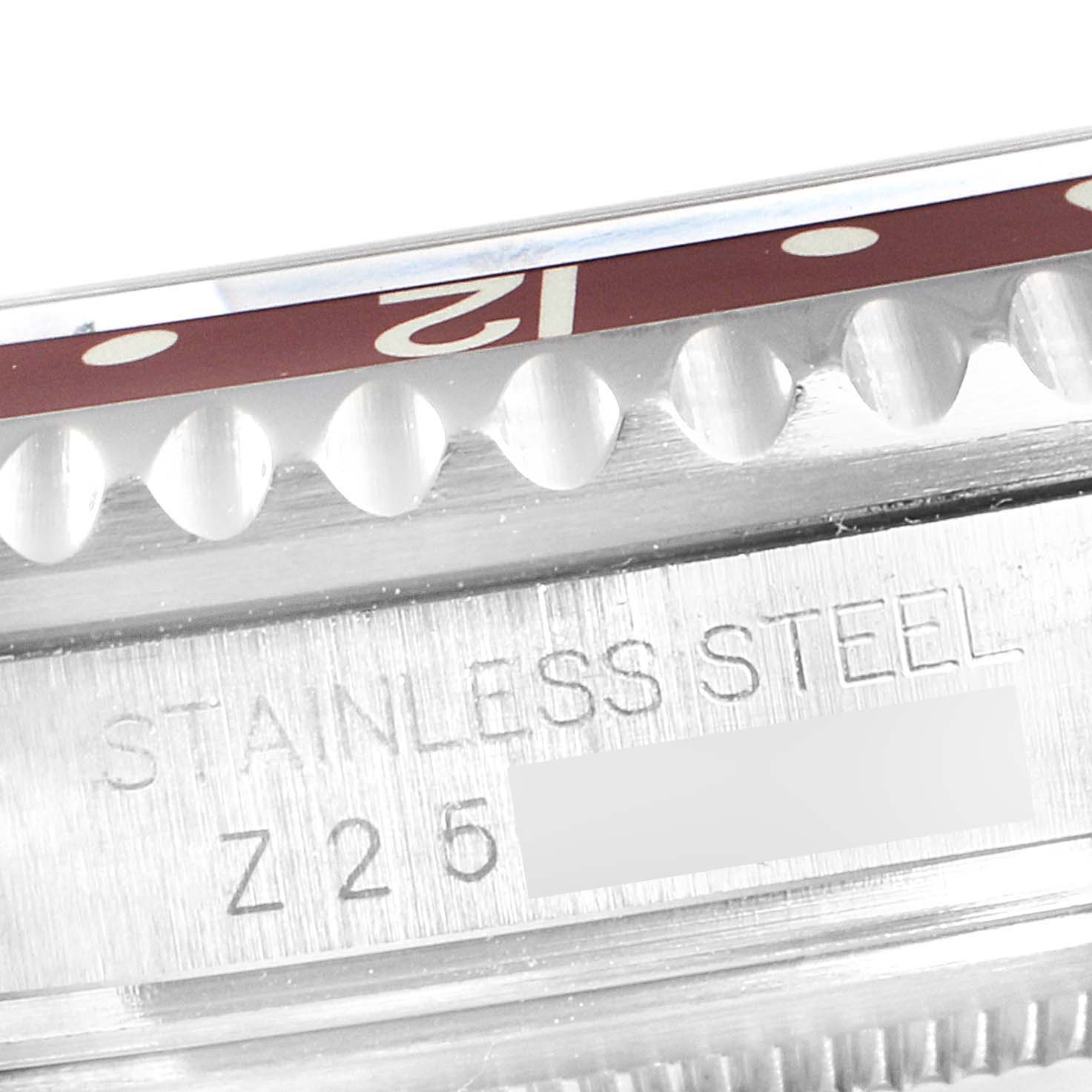 This close-up image of the Rolex GMT-Master 16710 Men's Stainless Steel Black Dial 16710 Men's Stainless Steel Black Dial shows the bezel and part of the stainless steel case with engraving.