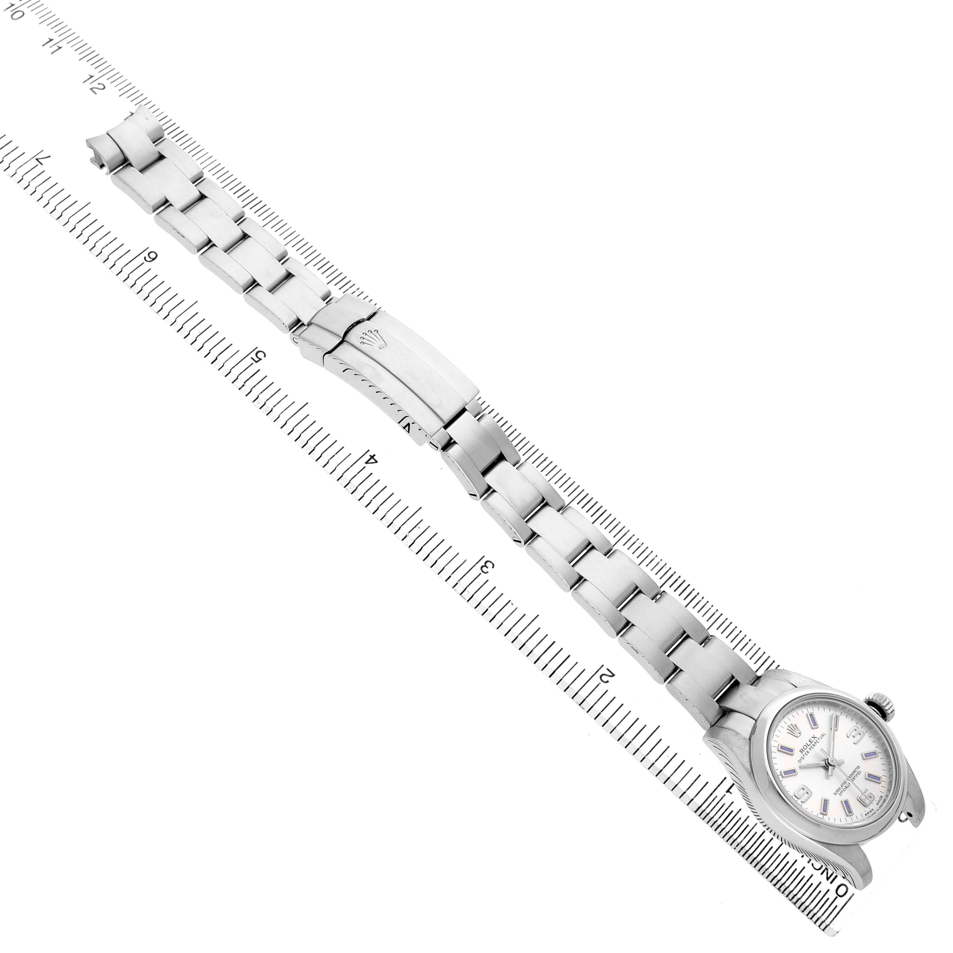 The Rolex Oyster Perpetual 176200 Women's Stainless Steel Silver Dial watch is shown from an overhead angle, displaying its bracelet and clasp extended on a ruler.
