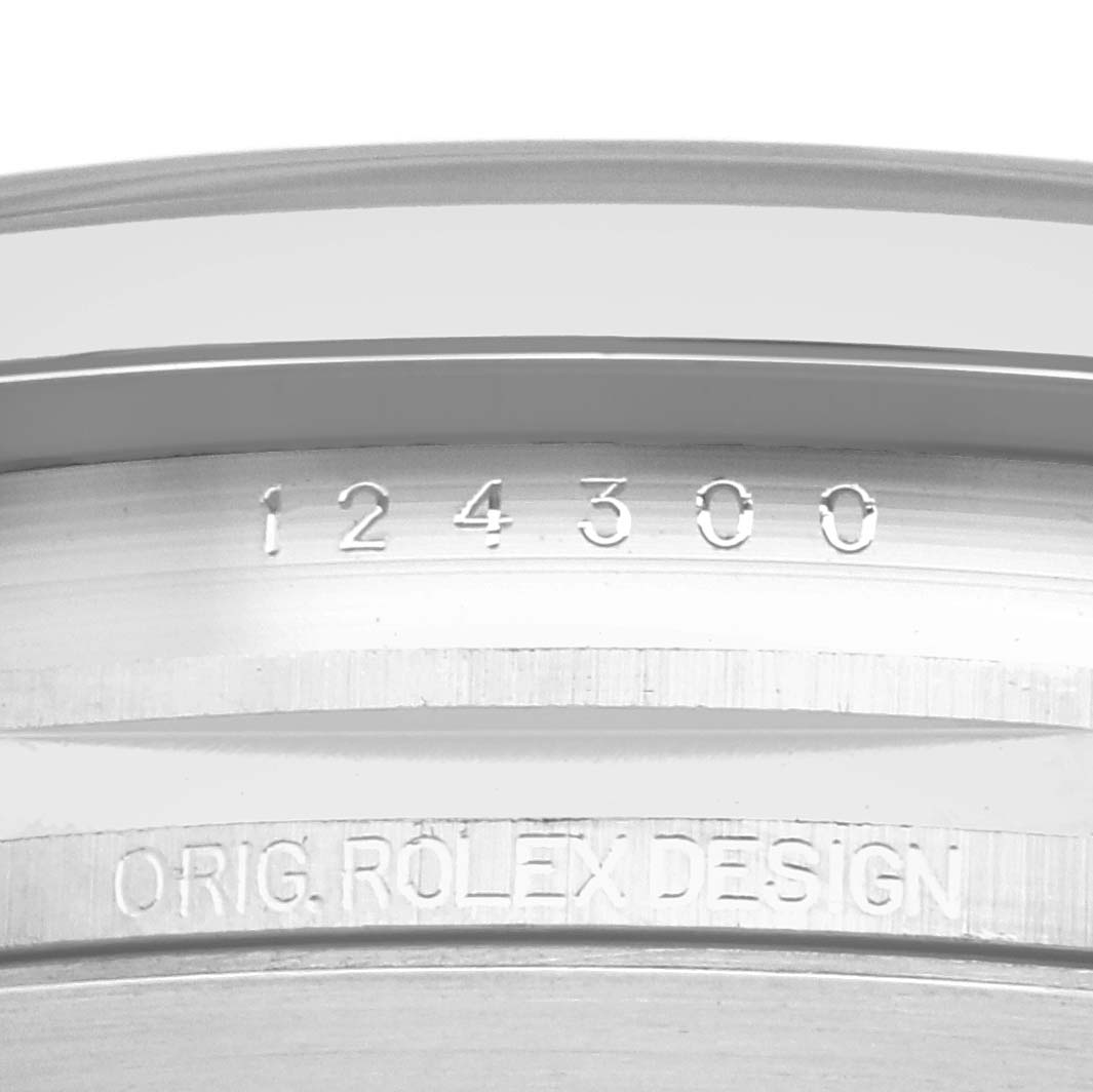The image shows a close-up of the inner bezel engravings of a Rolex Oyster Perpetual 124300 Men
s Stainless Steel Blue Dial watch, displaying the model number.