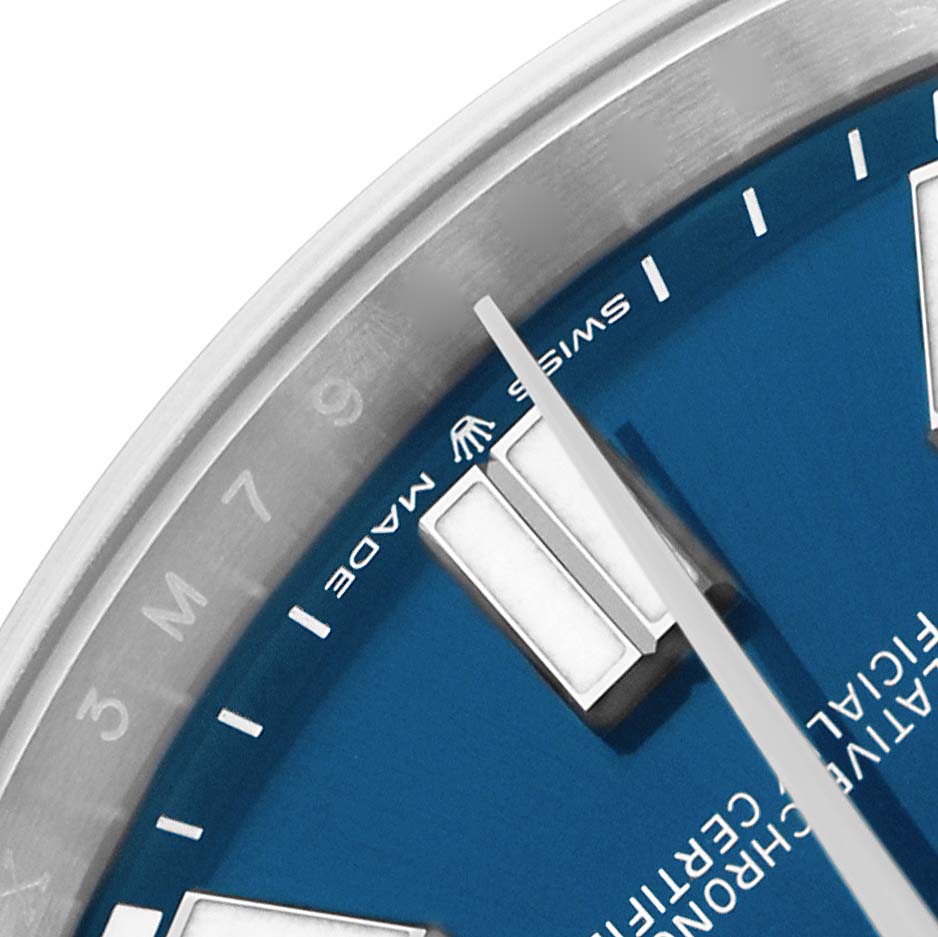 The image shows a close-up of the dial and bezel of a Rolex Oyster Perpetual 124300 Men
s Stainless Steel Blue Dial watch, highlighting the indices and "Swiss Made" text.
