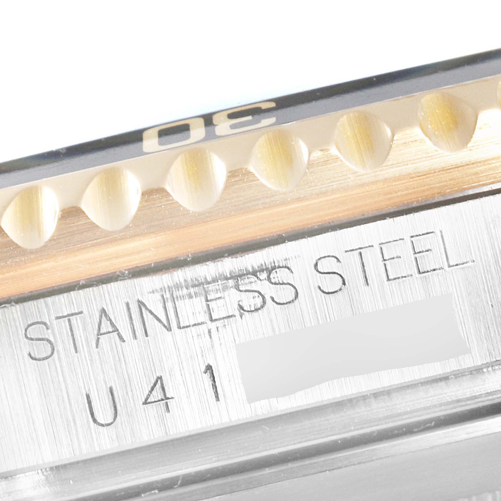 This close-up image of a Rolex Submariner 16613 Men
s Steel and Gold (two tone) Black Dial 16613 Men
s Steel and Gold (two tone) Black Dial watch shows the edge of the bezel and the stainless steel engraving.