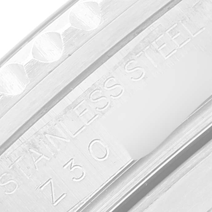 The image shows an extreme close-up of the Rolex Submariner 16610 Men
s Stainless Steel Black Dial 16610 Men
s Stainless Steel Black Dial
s stainless steel case, featuring engraved text.