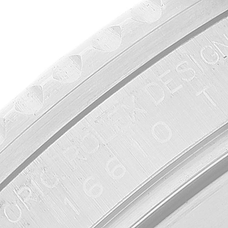 The image shows an extreme close-up of the engraved inner bezel of a Rolex Submariner 16610 Men
s Stainless Steel Black Dial 16610 Men
s Stainless Steel Black Dial, capturing inscription details.