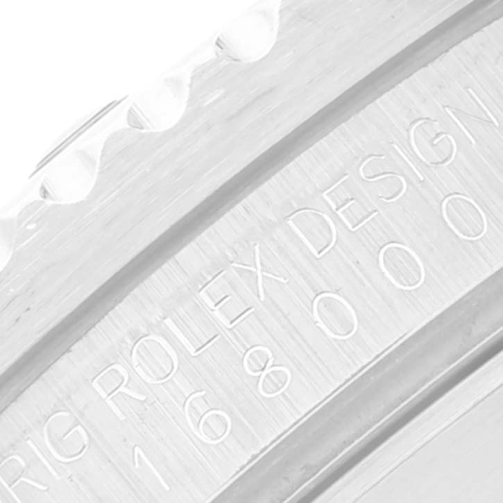 This close-up image shows the edge and engraved serial number of a Rolex Submariner 16800 Men
s Stainless Steel Black Dial 16800 Men
s Stainless Steel Black Dial
s bezel.