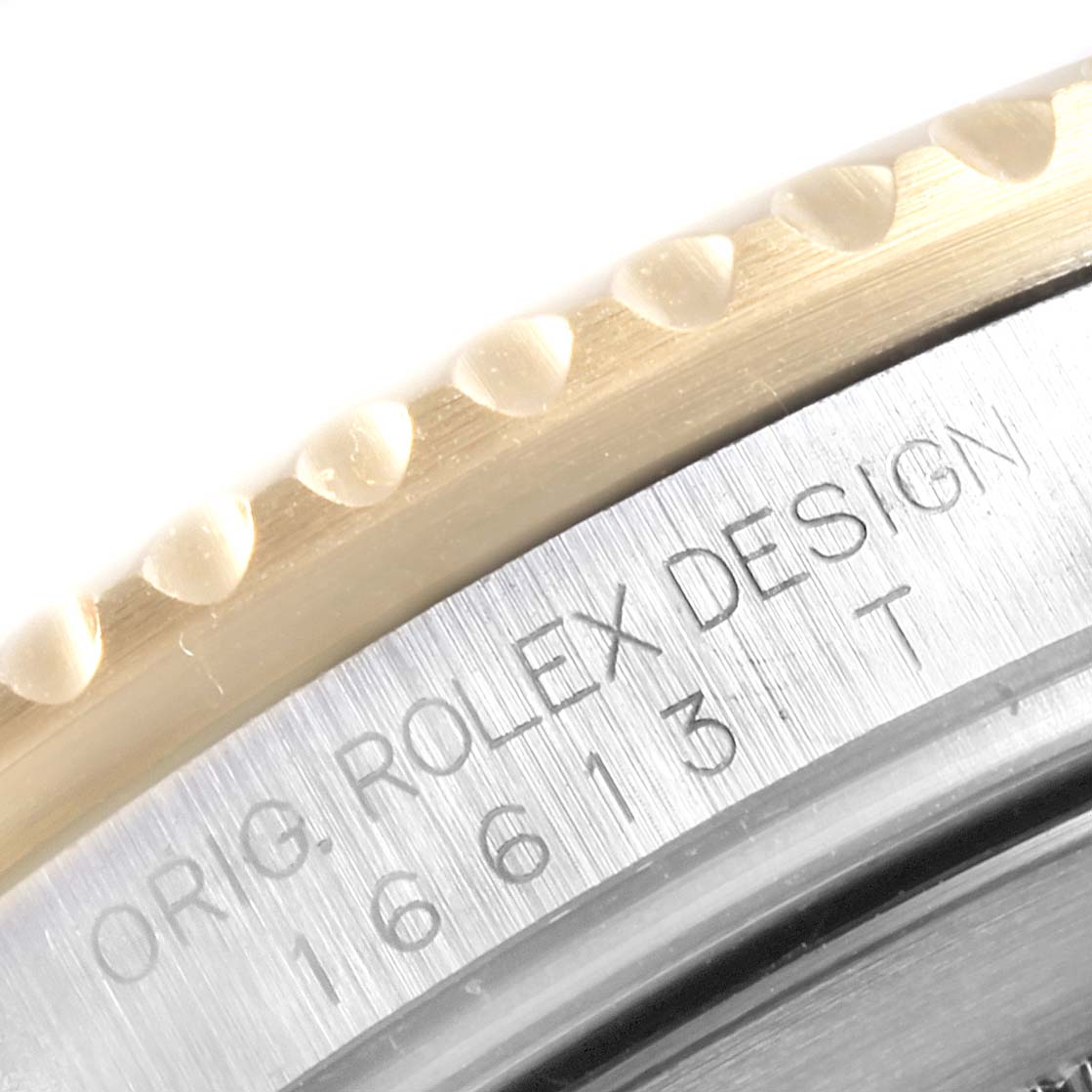 This image shows a close-up of the bezel and engraved case of a Rolex Submariner 16613 Men
s Steel and Gold (two tone) Grey Dial 16613 Men
s Steel and Gold (two tone) Grey Dial, showcasing the model number and "ORIG. ROLEX DESIGN" text.
