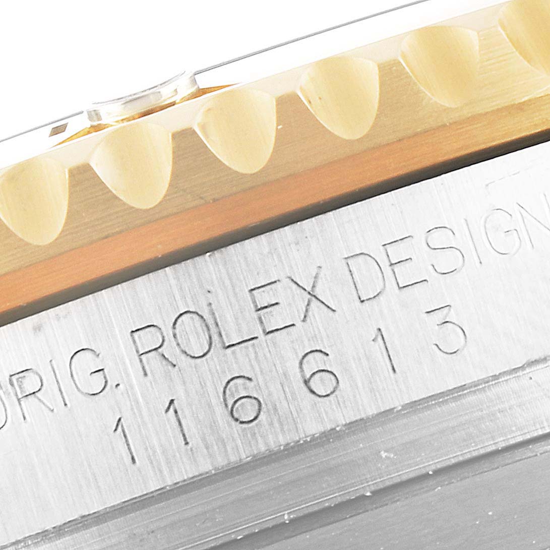 The image shows a close-up of the side view of a Rolex Submariner 116613 Men
s Steel and Gold (two tone) Black Dial 116613 Men
s Steel and Gold (two tone) Black Dial watch, focusing on its bezel and engraved reference number.