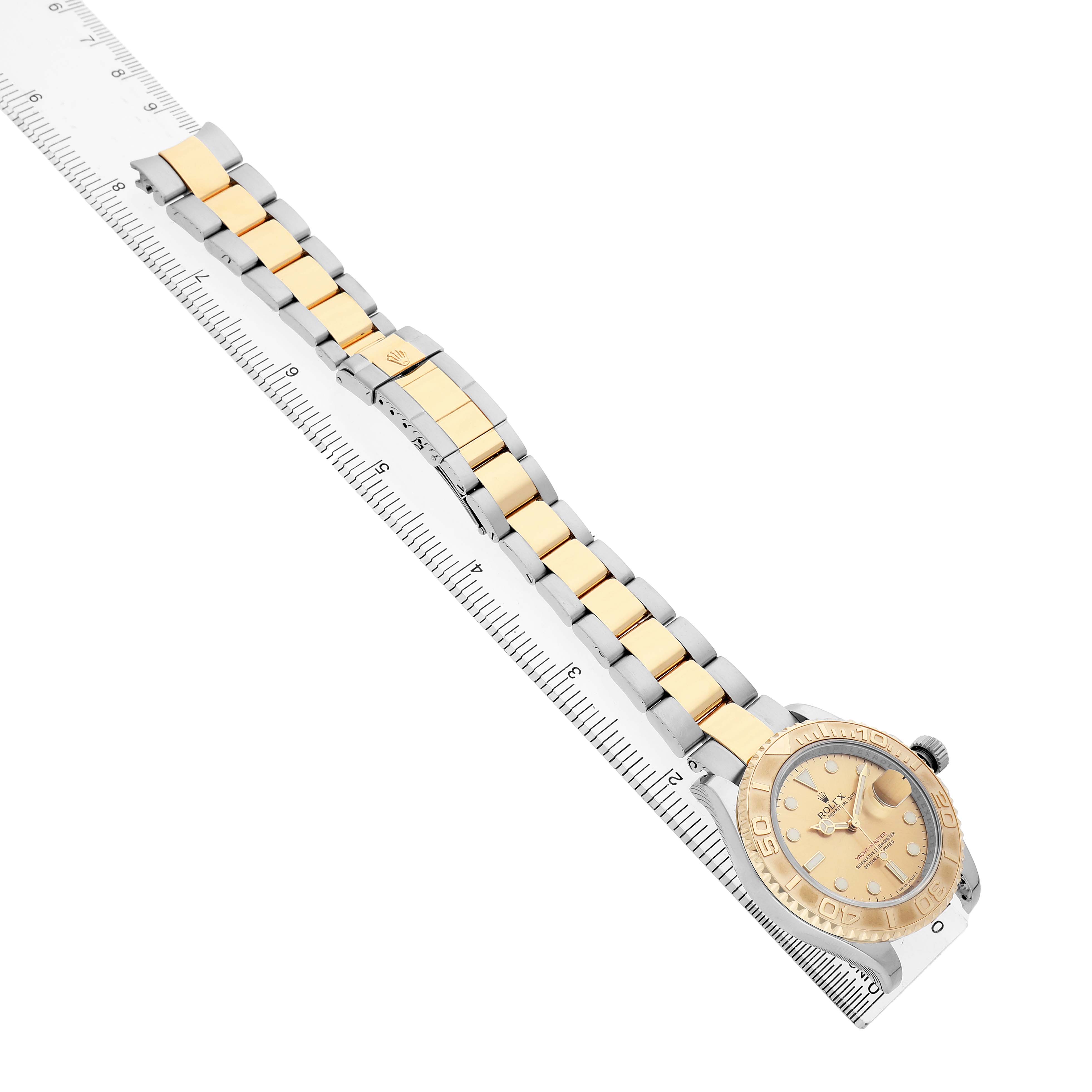 The Rolex Yacht-Master 16623 Men's Steel and Gold (two tone) Champagne Dial watch is shown at an oblique angle, displaying its face, bezel, and bracelet alongside a ruler for scale.
