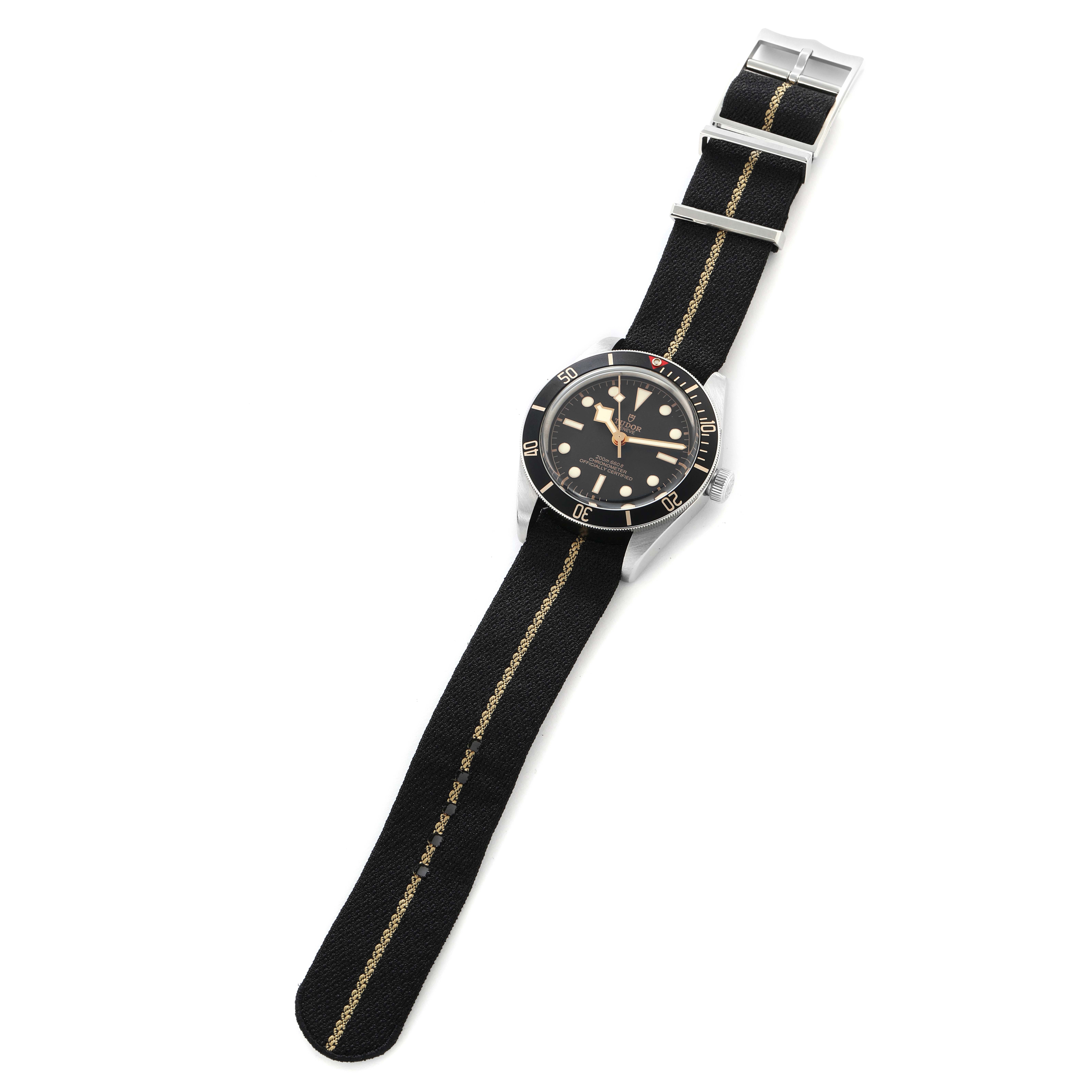 The Tudor Heritage Black Bay 79030N Men
s Stainless Steel Black Dial watch is shown at a top-down angle, displaying the face, bezel, strap, and buckle.