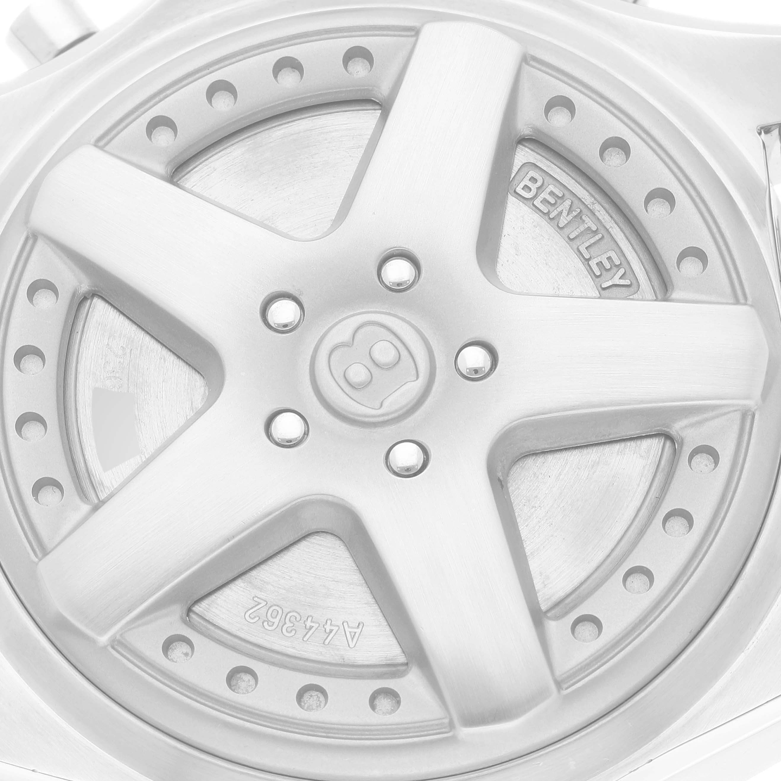 The image shows a close-up of the wheel-shaped case back of the Breitling Bentley A44362 Men's Stainless Steel Silver Dial A44362 Men's Stainless Steel Silver Dial watch, with "BENTLEY" engraved on it.
