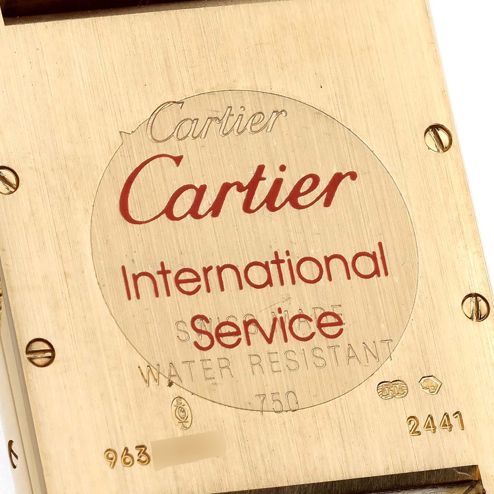 This image shows the back case of a Tank Louis model by Cartier, highlighting engraving details and serial numbers.