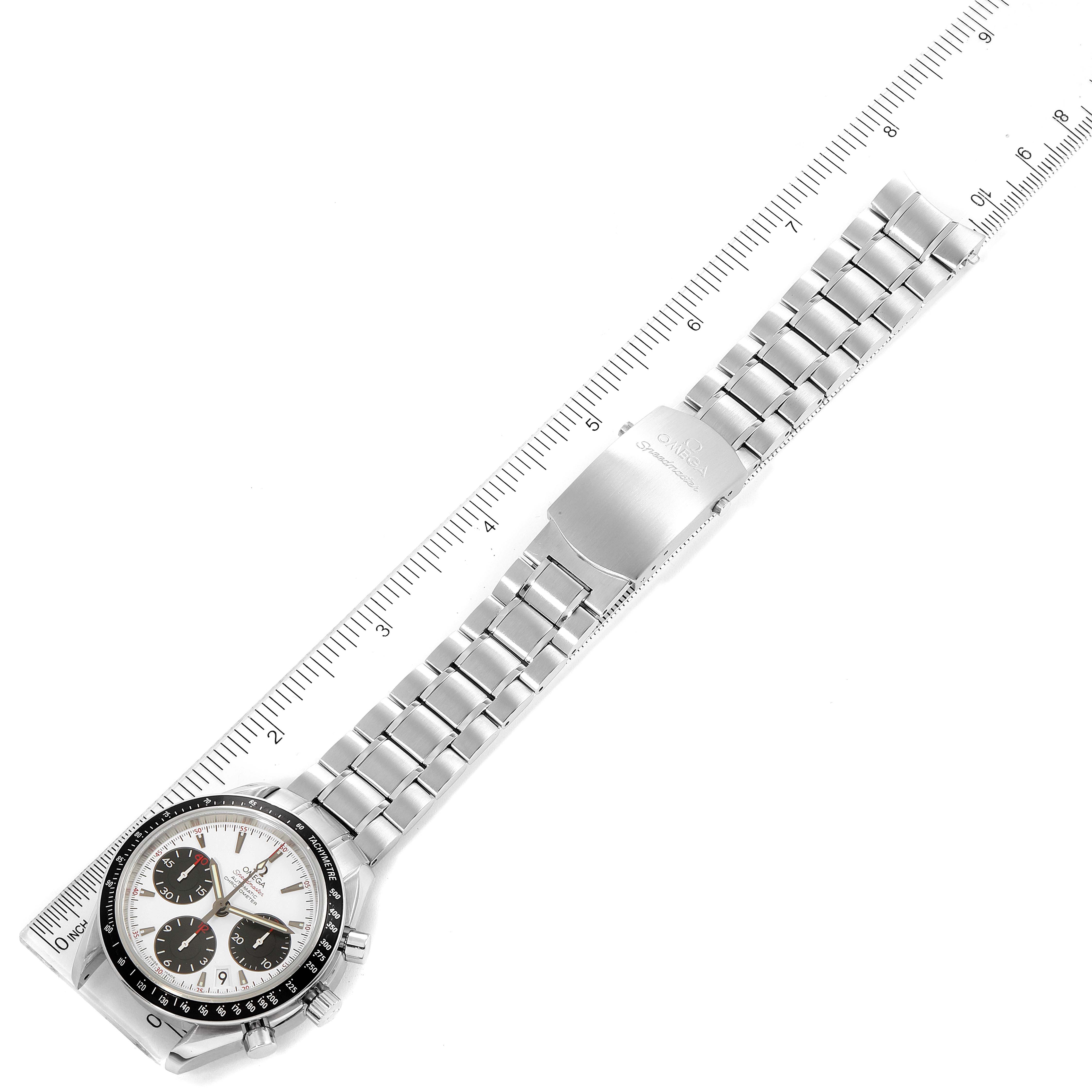 The image shows an overhead view of the Omega Speedmaster 323.30.40.40.04.001 Men's Stainless Steel White Dial 323.30.40.40.04.001 Men's Stainless Steel White Dial watch, displaying its face, bezel, and entire metal bracelet laid beside a ruler.