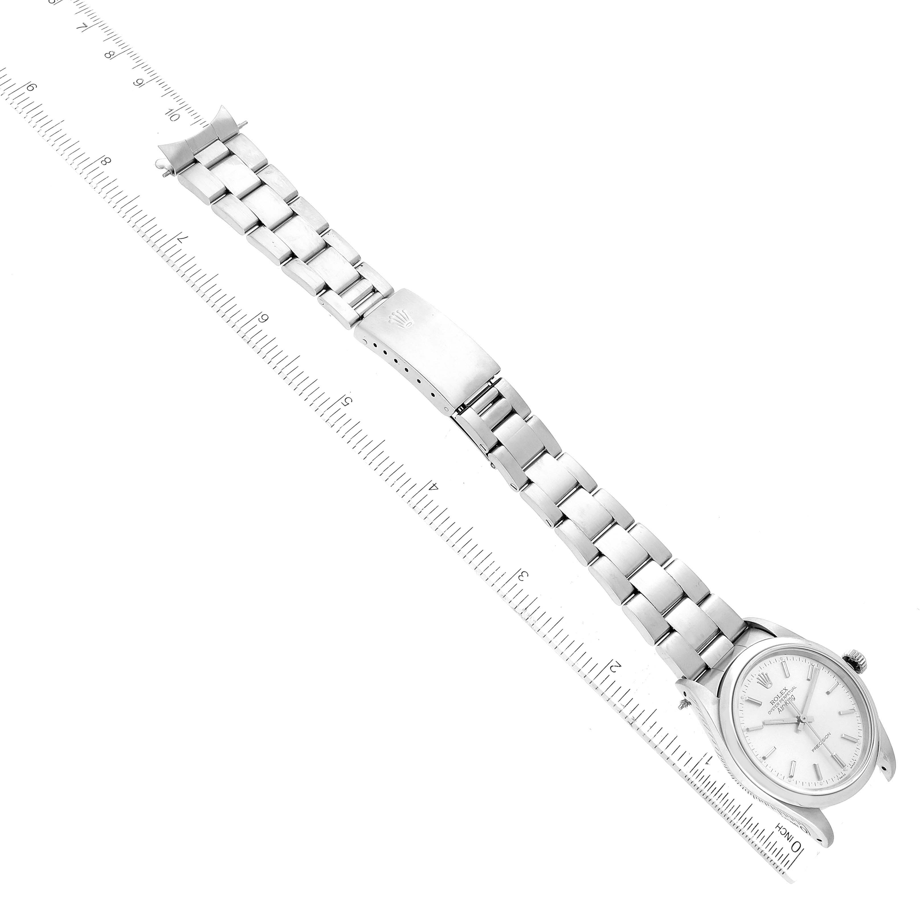 The image shows an overhead view of a Rolex Air-King 14000 Men's Stainless Steel Silver Dial 14000 Men's Stainless Steel Silver Dial watch with its stainless steel bracelet laid flat, alongside a ruler for scale.