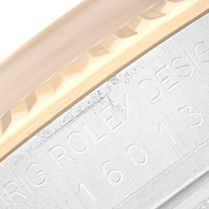 This close-up image of a Rolex Datejust 16013 Men's Steel and Gold (two tone) Champagne Dial 16013 Men's Steel and Gold (two tone) Champagne Dial watch shows the engraved design number beneath the fluted bezel.