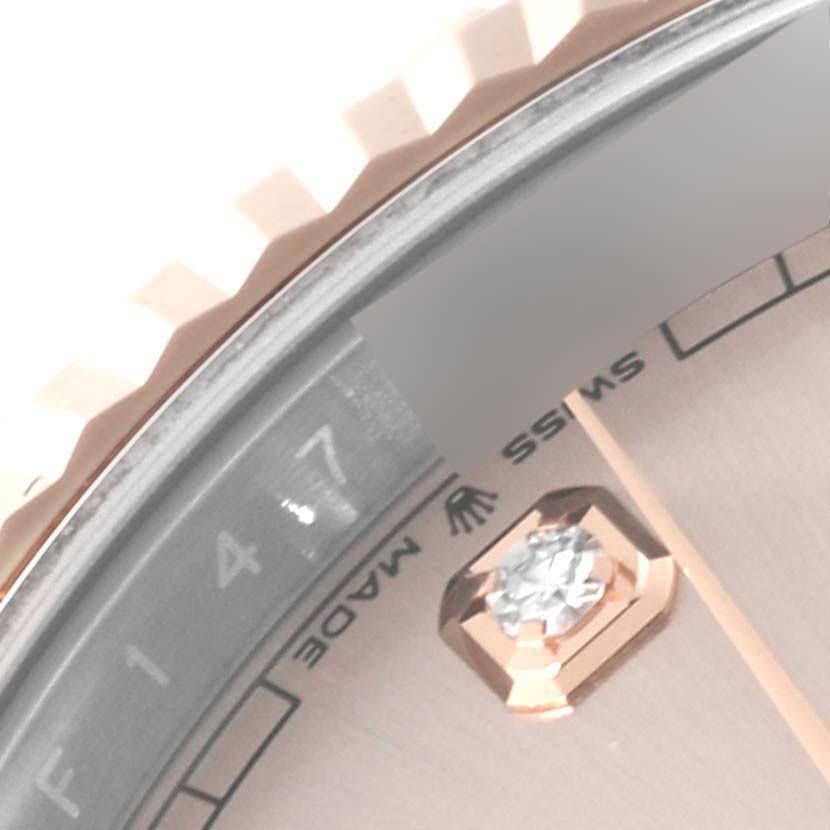 This close-up angle of the Rolex Datejust 41 126331 Men's Steel and Gold (two tone) Pink Dial 126331 Men's Steel and Gold (two tone) Pink Dial watch shows part of the bezel, dial with a diamond marker, and "Swiss Made" inscription.