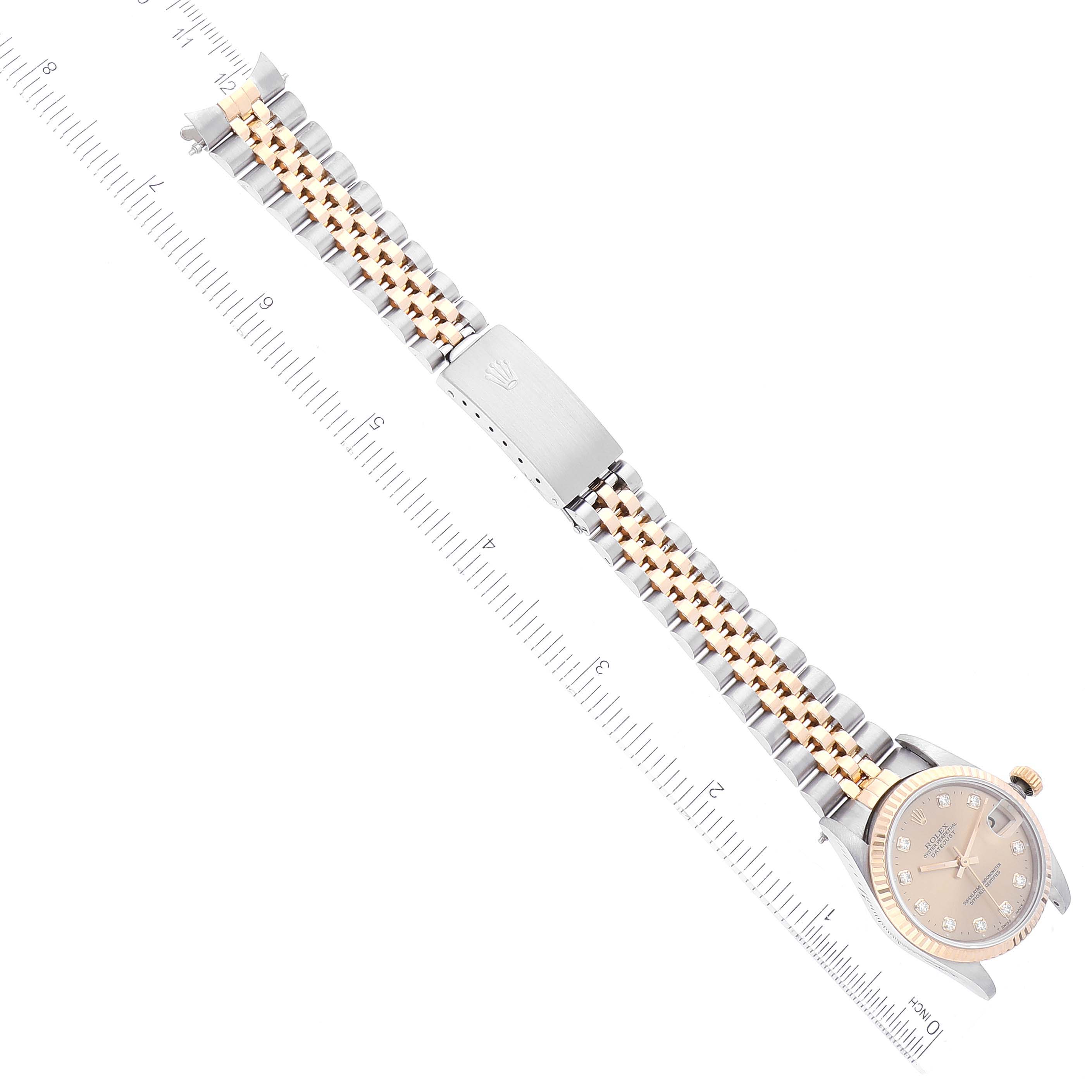 The image shows a top view of a Rolex Mid-Size 68273 Women's Steel and Gold (two tone) Champagne Dial 68273 Women's Steel and Gold (two tone) Champagne Dial watch, displaying its face, two-tone bracelet, and clasp, with a ruler for scale.