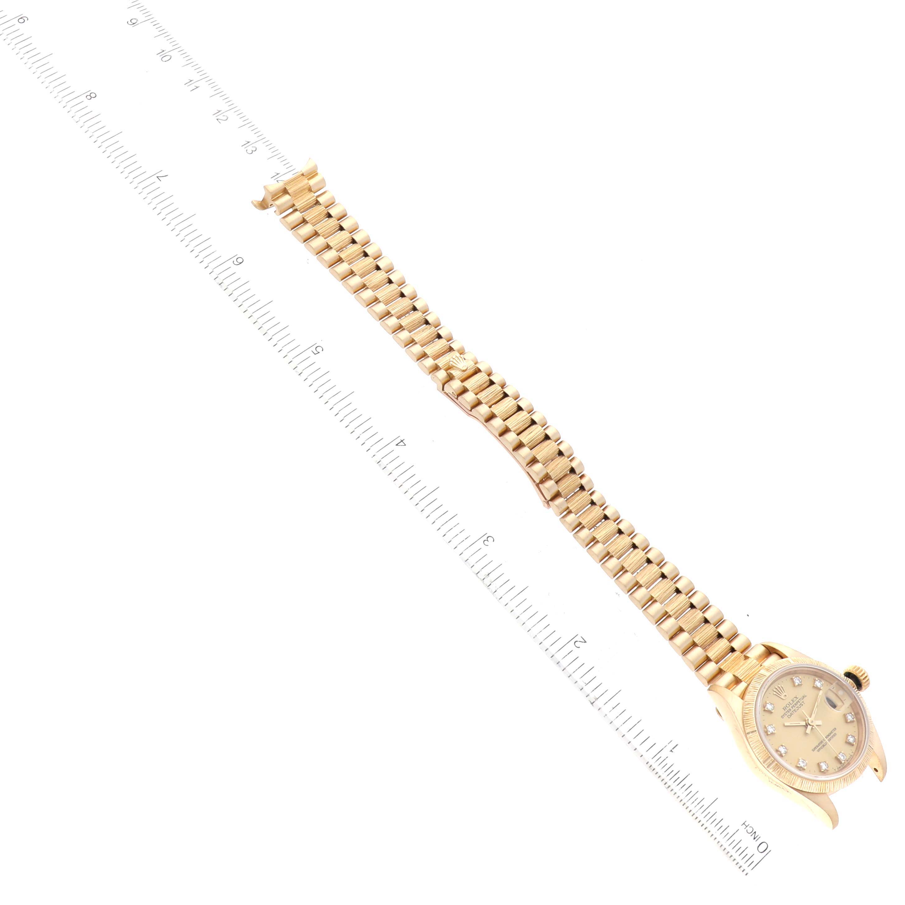 The image shows a Rolex Datejust 69278 Women's Yellow Gold Champagne Dial 69278 Women's Yellow Gold Champagne Dial watch from an overhead angle, featuring the watch face, bezel, and entire bracelet aligned with a ruler.