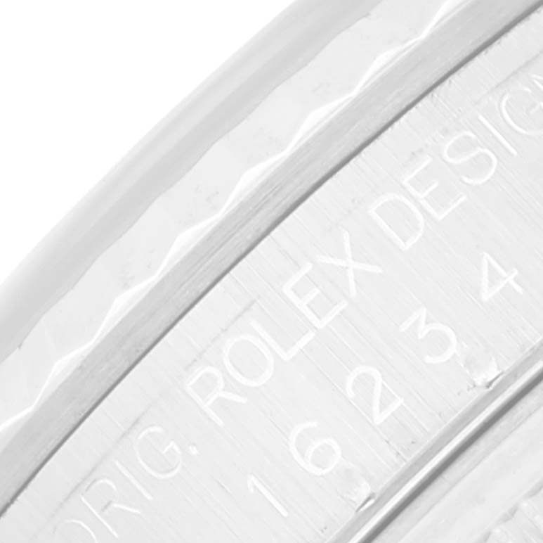 This image shows a close-up angle of the engraved bezel of a Rolex Datejust 16234 Men's Stainless Steel Pink Dial 16234 Men's Stainless Steel Pink Dial watch, highlighting the text "ORIG. ROLEX DESIGN" and some numbers.