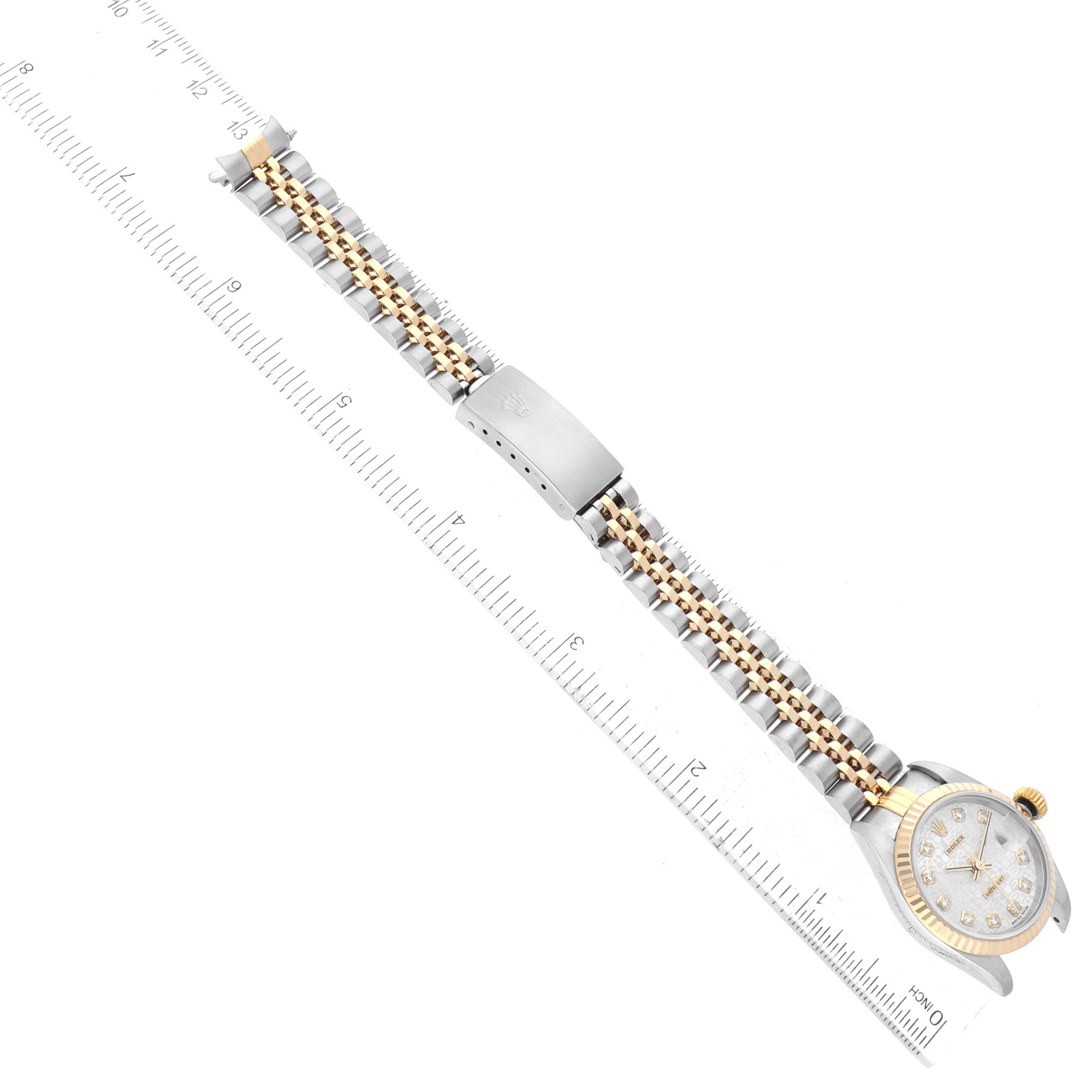 The image shows a top-down view of a Rolex Datejust 79173 Women's Steel and Gold (two tone) Silver Dial 79173 Women's Steel and Gold (two tone) Silver Dial watch with a bi-metal bracelet and clasp, aligned along a ruler.