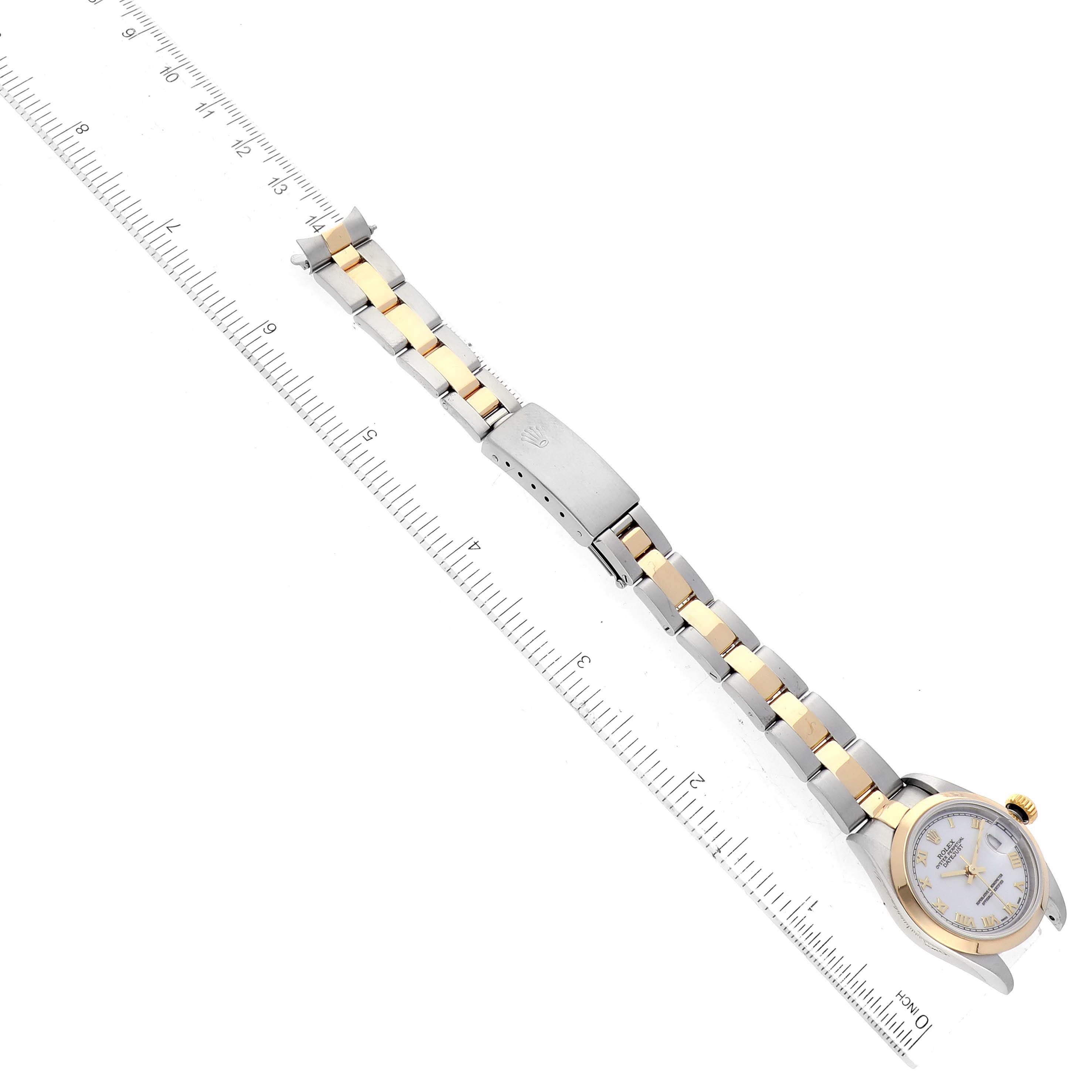 The image shows a Rolex Datejust 79163 Women's Steel and Gold (two tone) White Dial 79163 Women's Steel and Gold (two tone) White Dial watch laid flat next to a ruler, highlighting its two-tone bracelet and clasp.