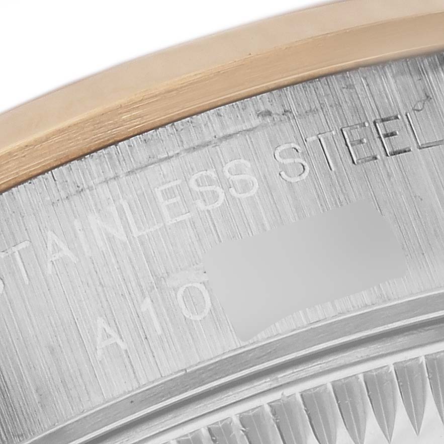 This is a close-up of a portion of the bezel and case with engraved text from a Rolex Datejust 79163 Women's Steel and Gold (two tone) White Dial 79163 Women's Steel and Gold (two tone) White Dial model watch.