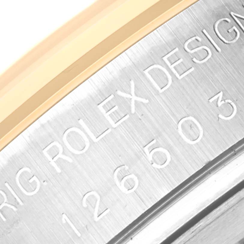 The image shows a close-up of the serial number and engraving on the side of the Rolex Daytona 126503 Men's Steel and Gold (two tone) White Dial 126503 Men's Steel and Gold (two tone) White Dial watch case.