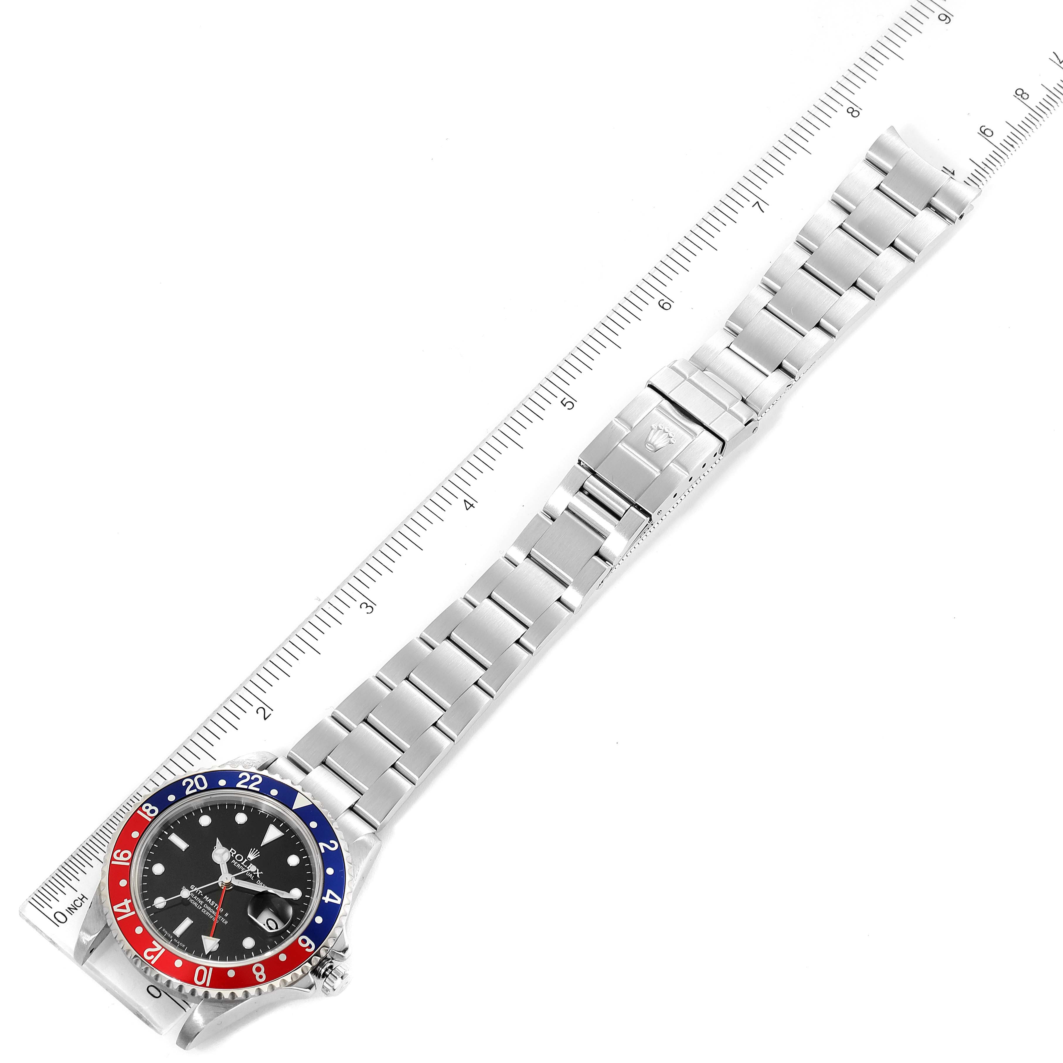 The image shows a top-down view of a Rolex GMT-Master 16710 Men's Stainless Steel Black Dial 16710 Men's Stainless Steel Black Dial watch, displaying its bezel, dial, and entire bracelet against a ruler.