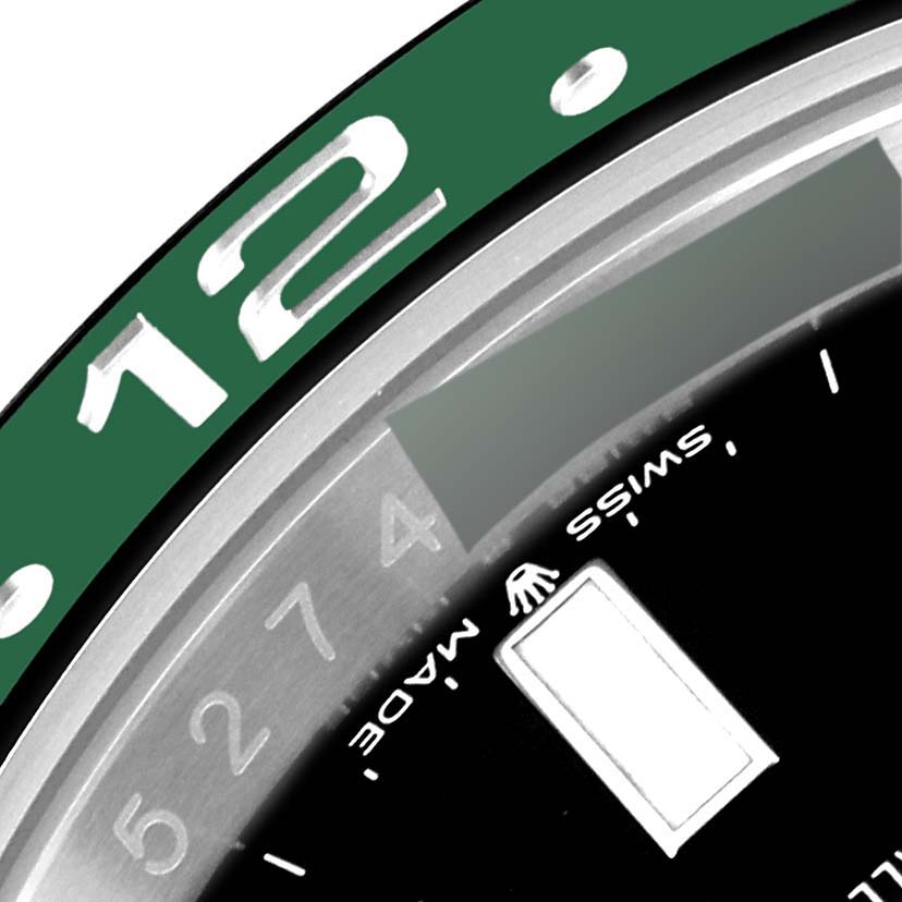 The image shows a close-up of the bezel and dial edge of a Rolex GMT-Master 126720VTNR-0001 Men's Stainless Steel Black Dial 126720VTNR-0001 Men's Stainless Steel Black Dial watch, featuring the "12" marker and part of the "Swiss Made" text.