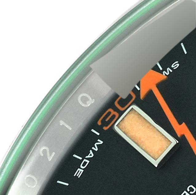 Close-up of the dial of the Rolex Milgauss 116400 Men
s Stainless Steel Black Dial 116400 Men
s Stainless Steel Black Dial watch, showing the 3 o
clock mark, an orange lightning bolt second hand, and part of the bezel.