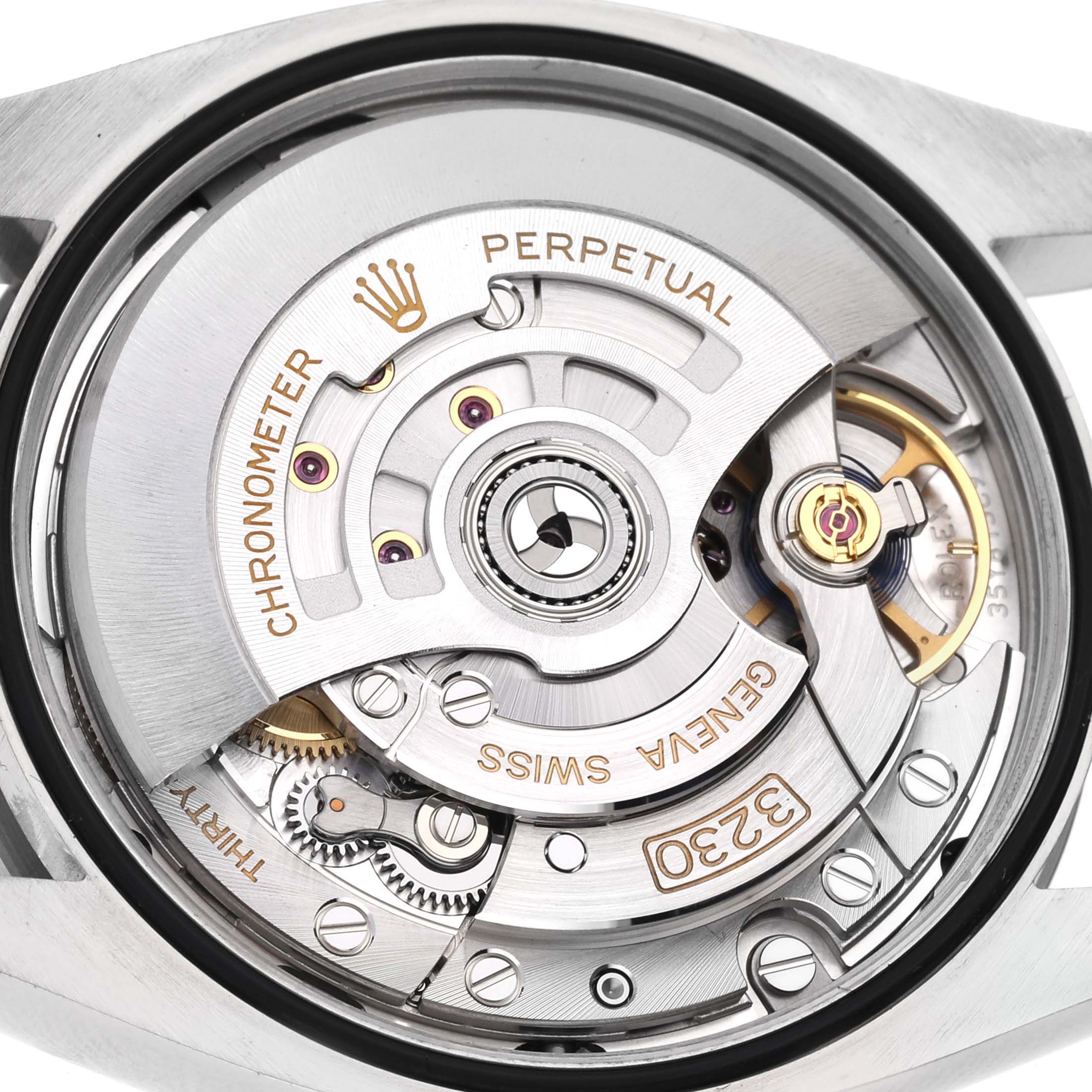 The image shows a close-up of the Rolex Oyster Perpetual 126000 Men
s Stainless Steel Blue Dial 126000 Men
s Stainless Steel Blue Dial model
s movement, displaying its intricate mechanical components and inscriptions.