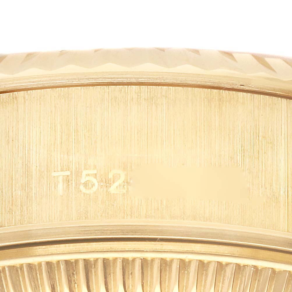 The image shows a close-up of the side of a Rolex Datejust 69178 Women's Yellow Gold Champagne Dial 69178 Women's Yellow Gold Champagne Dial watch, revealing part of the fluted bezel and serial number.