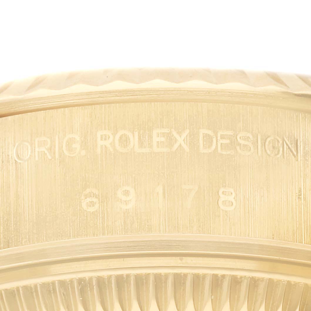 This image shows a close-up of the Rolex Datejust 69178 Women's Yellow Gold Champagne Dial 69178 Women's Yellow Gold Champagne Dial model, focusing on the engraved serial number and "ORIG. ROLEX DESIGN" inscription.