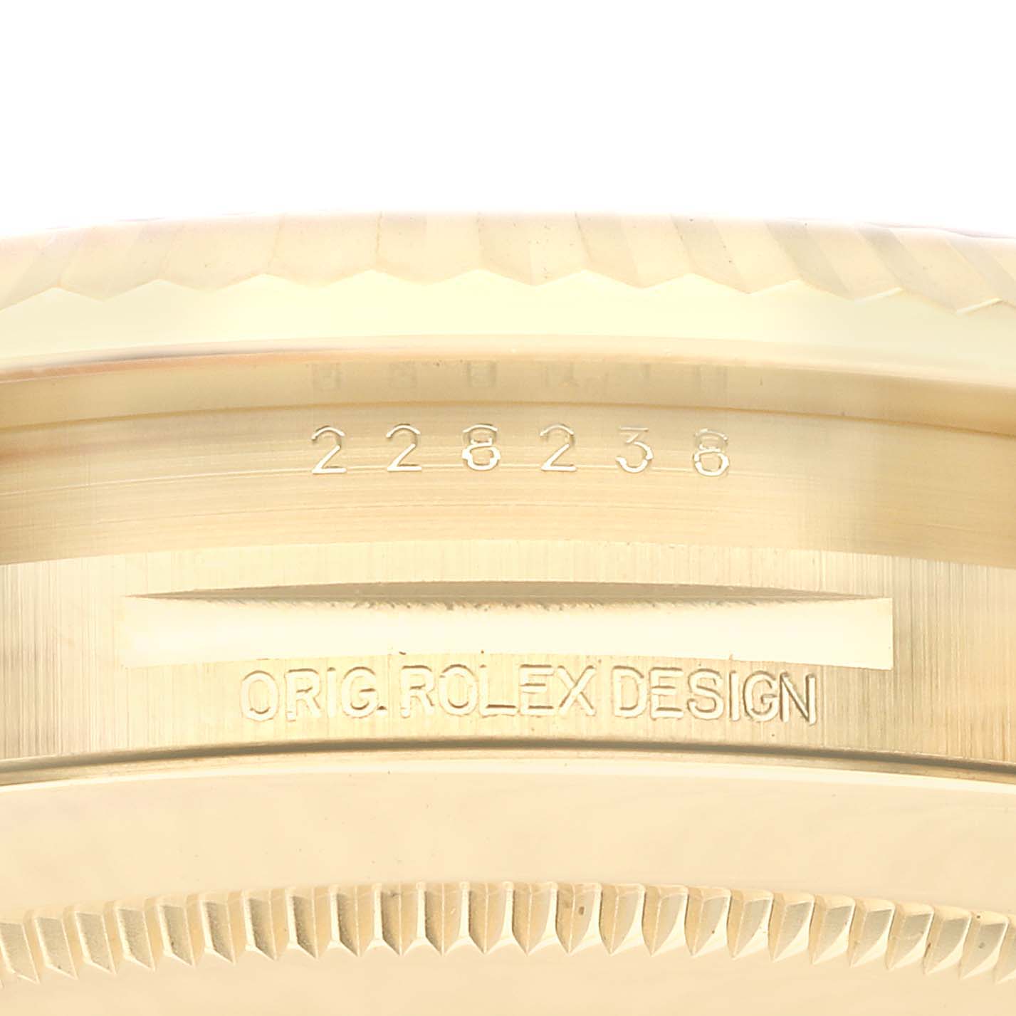 Close-up of the side view of a Rolex President 228238 Men
s Yellow Gold Silver Dial 228238 Men
s Yellow Gold Silver Dial watch, showing the model number and "Orig. Rolex Design" engraved.