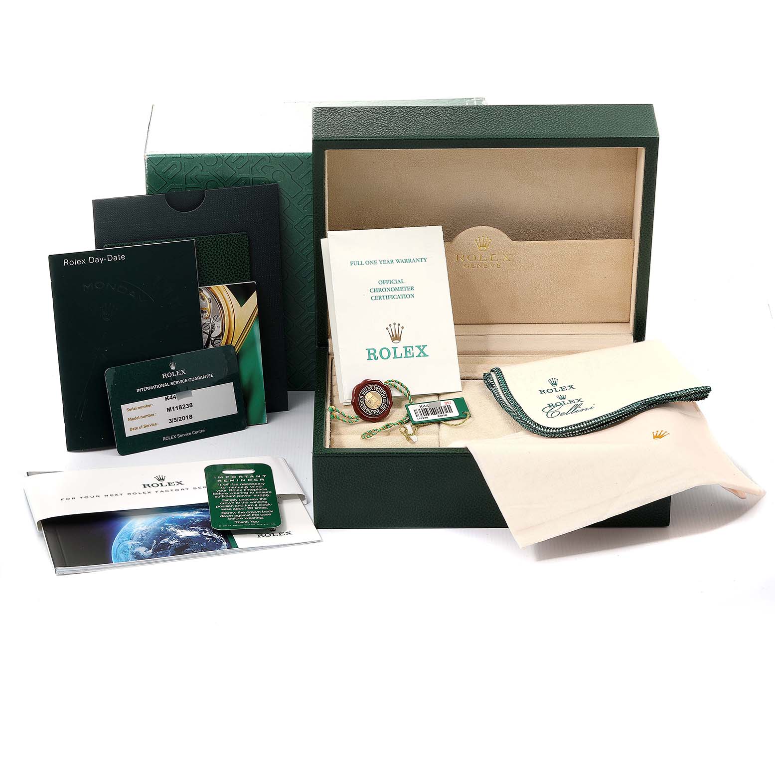 The image shows the packaging and accessories for a Rolex President 118238 Men
s Yellow Gold Black Dial 118238 Men
s Yellow Gold Black Dial model, including a box, warranty, tags, and cleaning cloths.