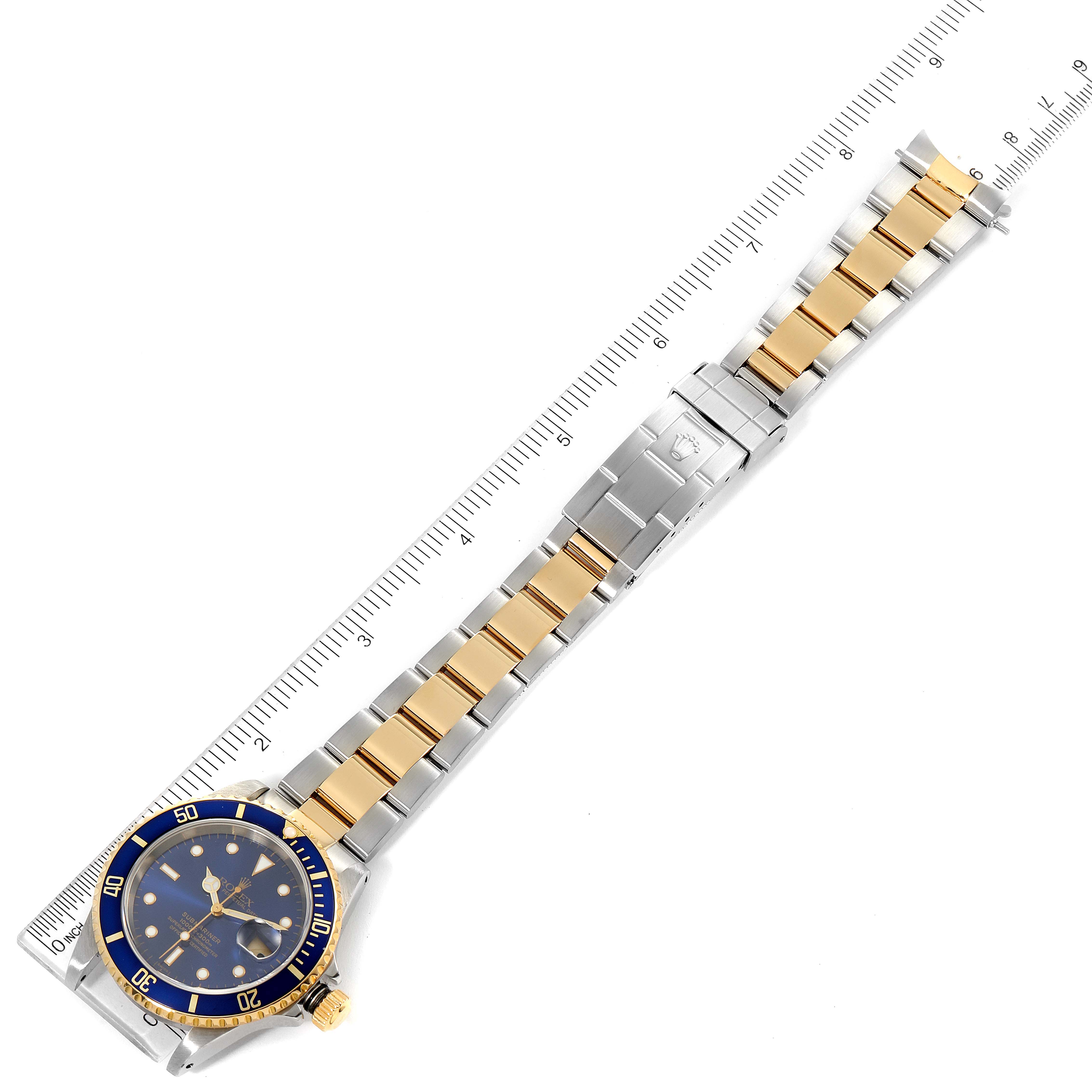 This image shows a Rolex Submariner 16613 Men's Steel and Gold (two tone) Blue Dial 16613 Men's Steel and Gold (two tone) Blue Dial watch laid flat, fully extended, with a ruler for size reference.
