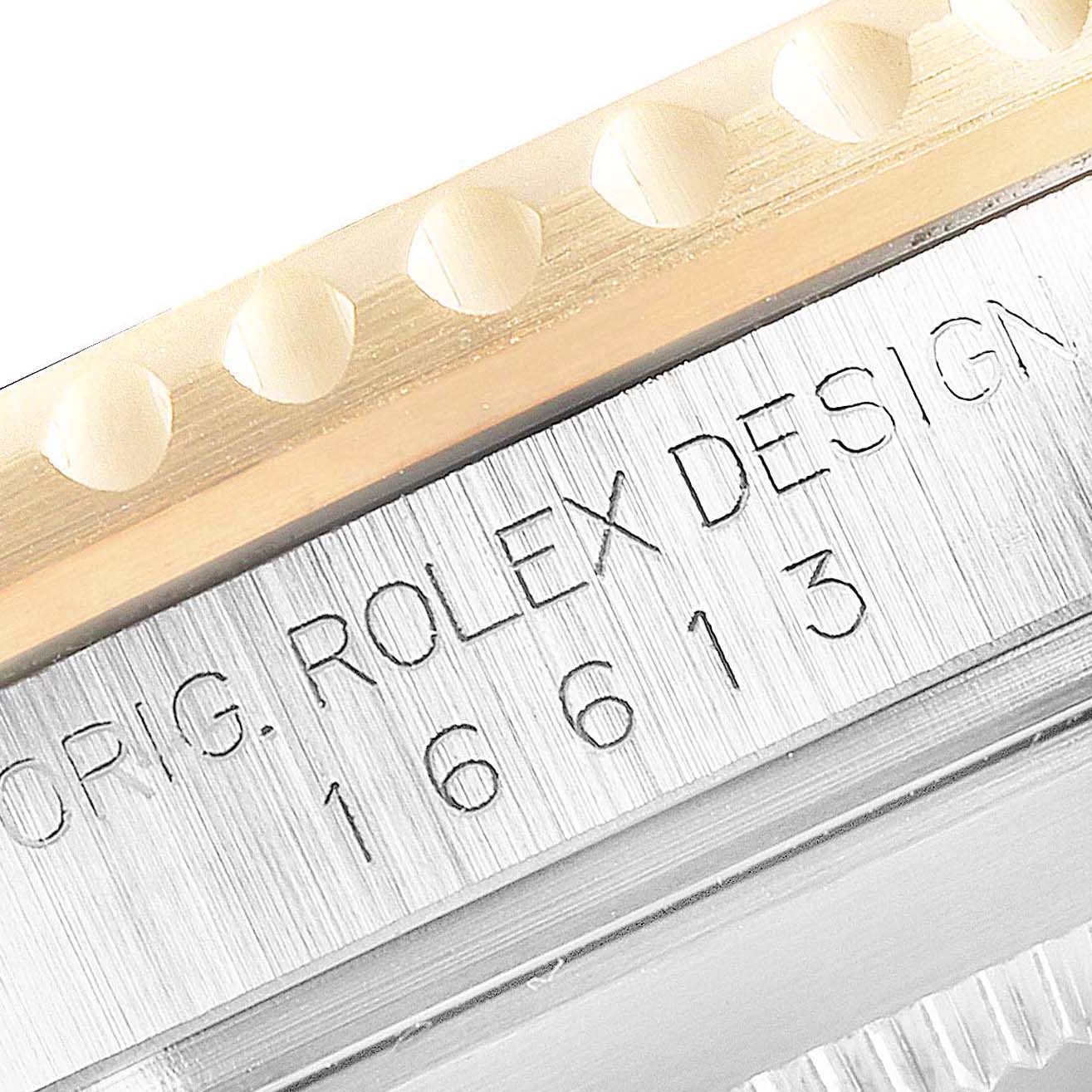 This image shows a close-up of the engraved side of the bezel and case of a Rolex Submariner 16613 Men's Steel and Gold (two tone) Blue Dial 16613 Men's Steel and Gold (two tone) Blue Dial watch.