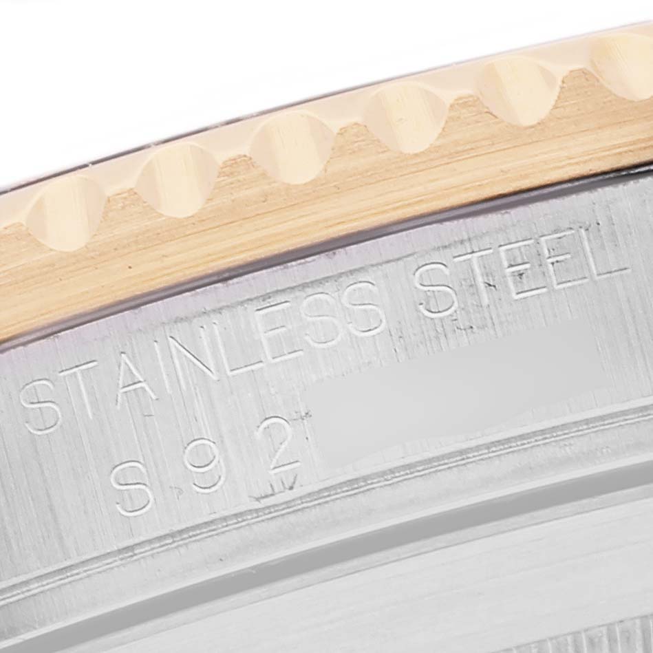 This close-up image of a Rolex Submariner 16613 Men's Steel and Gold (two tone) Blue Dial 16613 Men's Steel and Gold (two tone) Blue Dial watch shows part of the bezel and case, highlighting the "Stainless Steel" engraving.