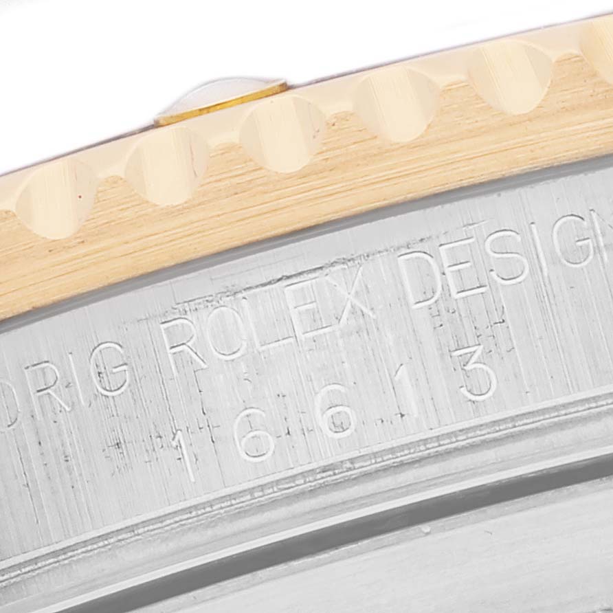 The image shows a close-up of the bezel and the case back of a Rolex Submariner 16613 Men's Steel and Gold (two tone) Blue Dial 16613 Men's Steel and Gold (two tone) Blue Dial watch.
