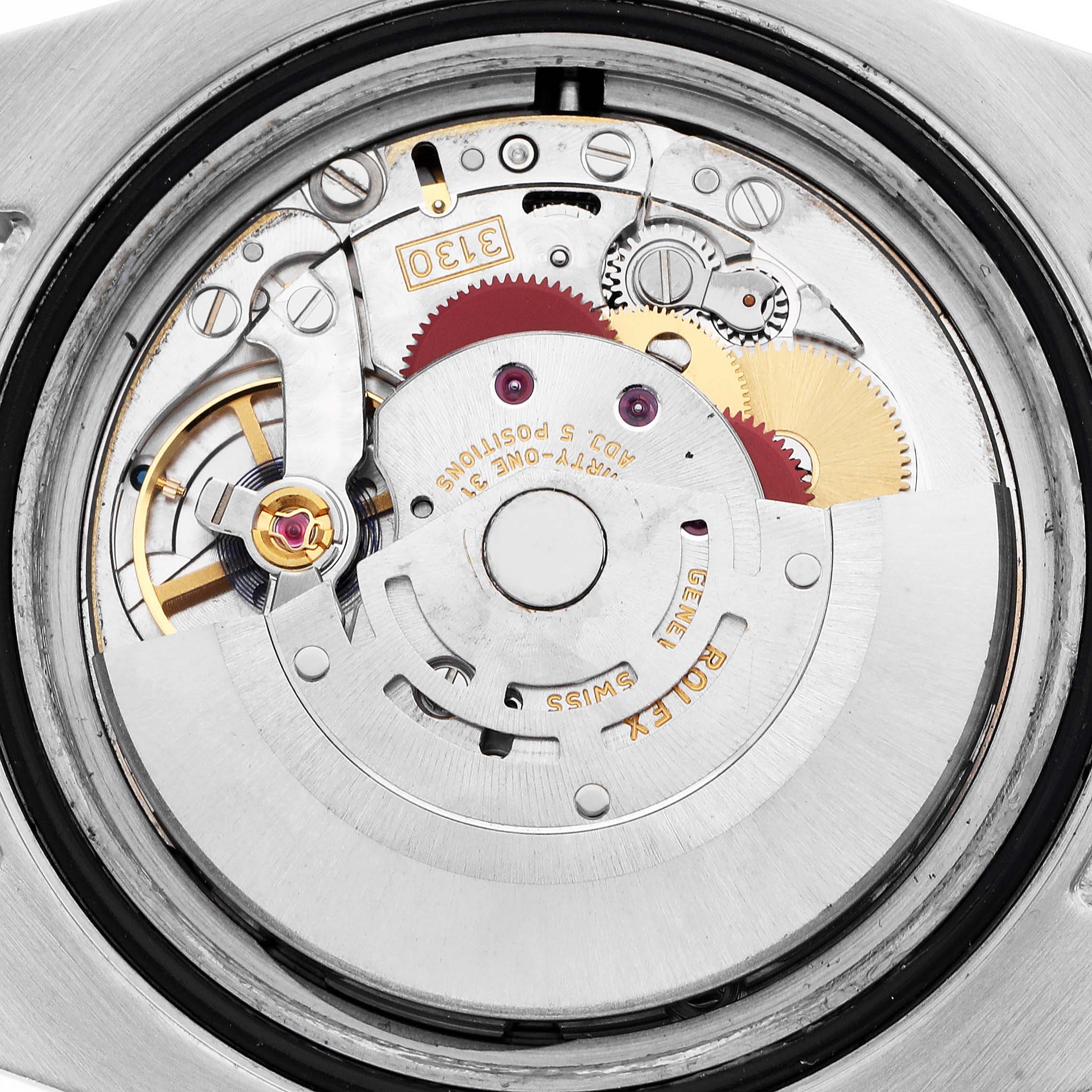 The image shows a close-up of the movement of a Rolex Submariner model 114060, highlighting the intricate gears and components inside the watch case.