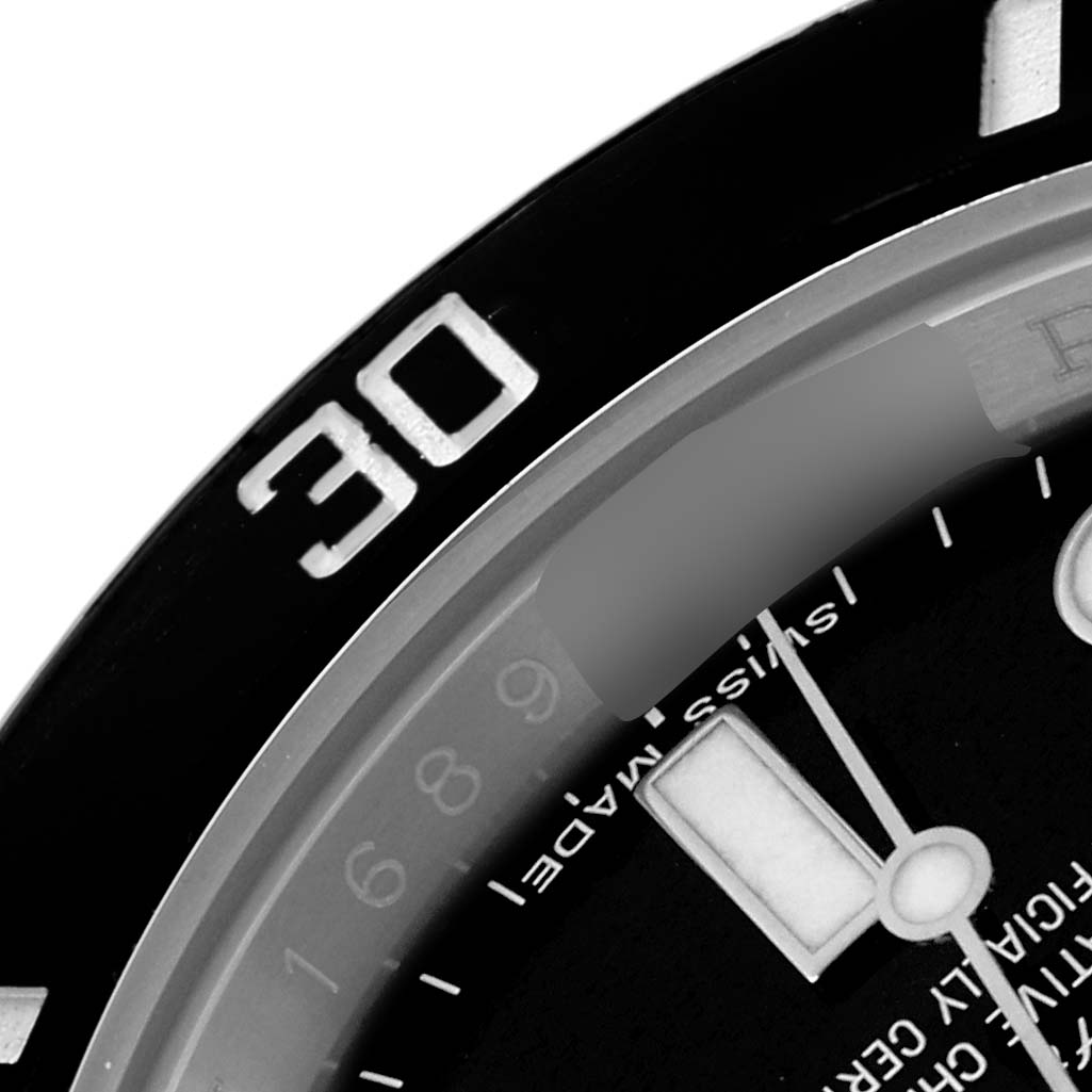 The image shows a close-up of the bezel and dial of a Rolex Submariner, model 114060, focusing on the 30-minute mark and part of the watch face.