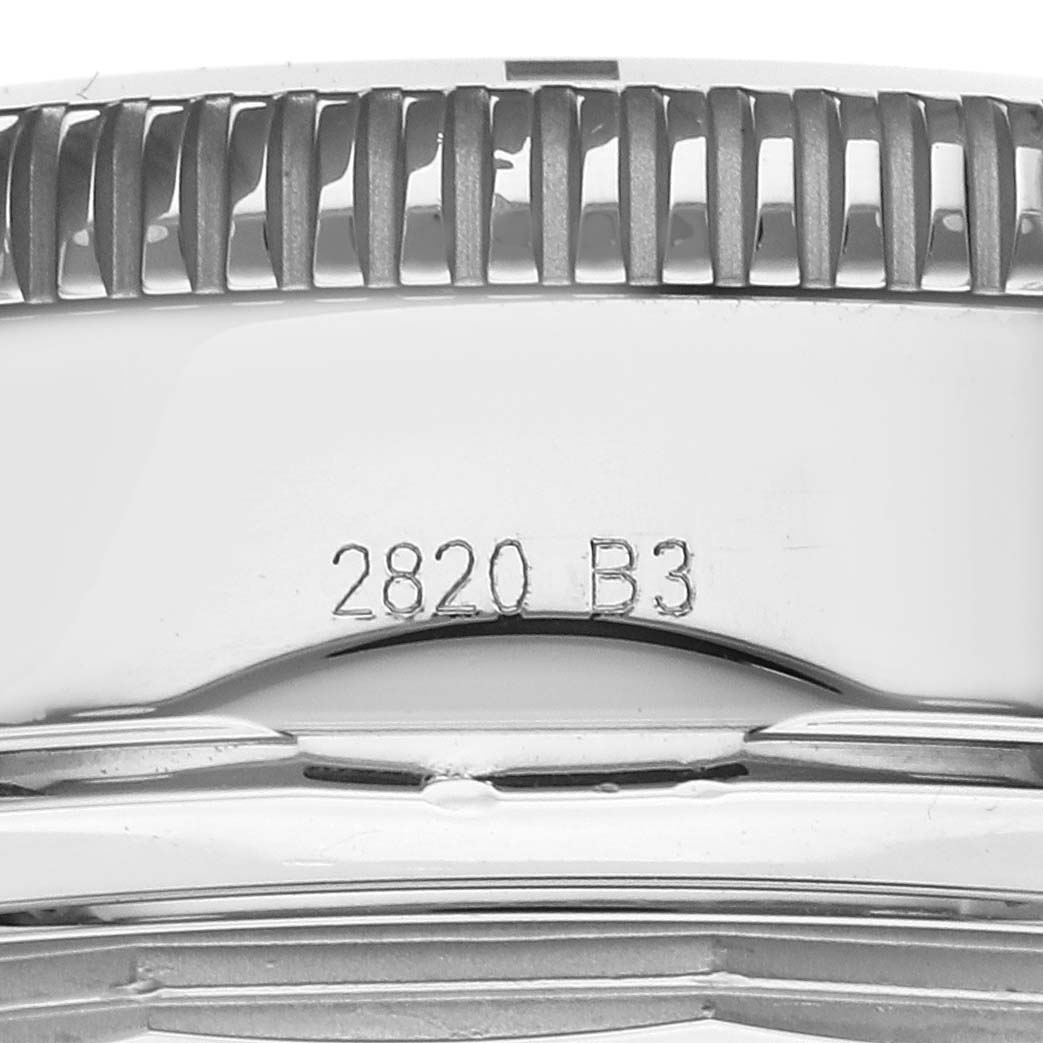 This image shows a macro view of the side of the Breitling Superocean AB0162 Men's Stainless Steel Blue Dial AB0162 Men's Stainless Steel Blue Dial watch case with engraved serial numbers.