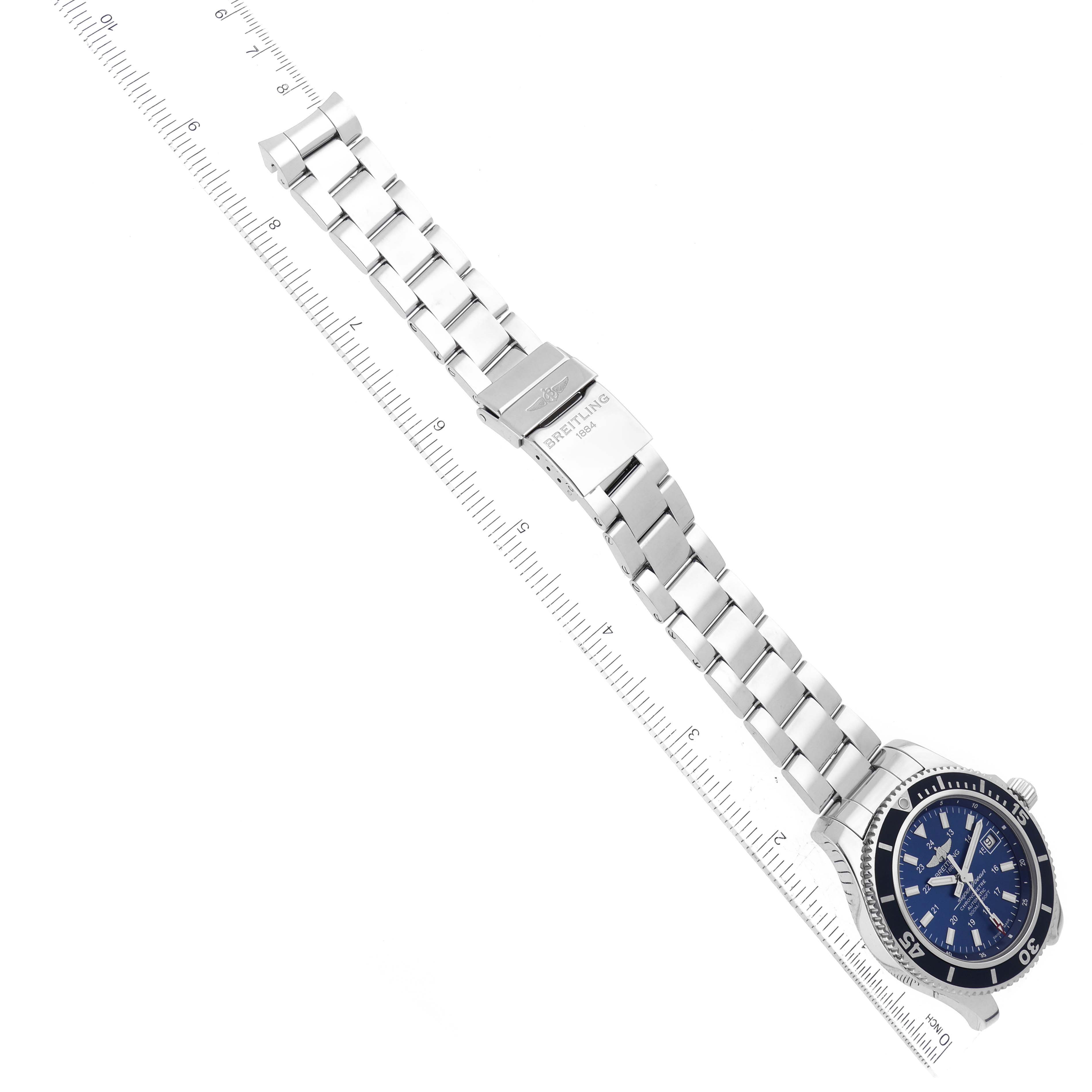 The image shows a Breitling Superocean A17365 Men
s Stainless Steel Blue Dial A17365 Men
s Stainless Steel Blue Dial watch with a metal bracelet, clasp, and the face, positioned next to a ruler for size reference.