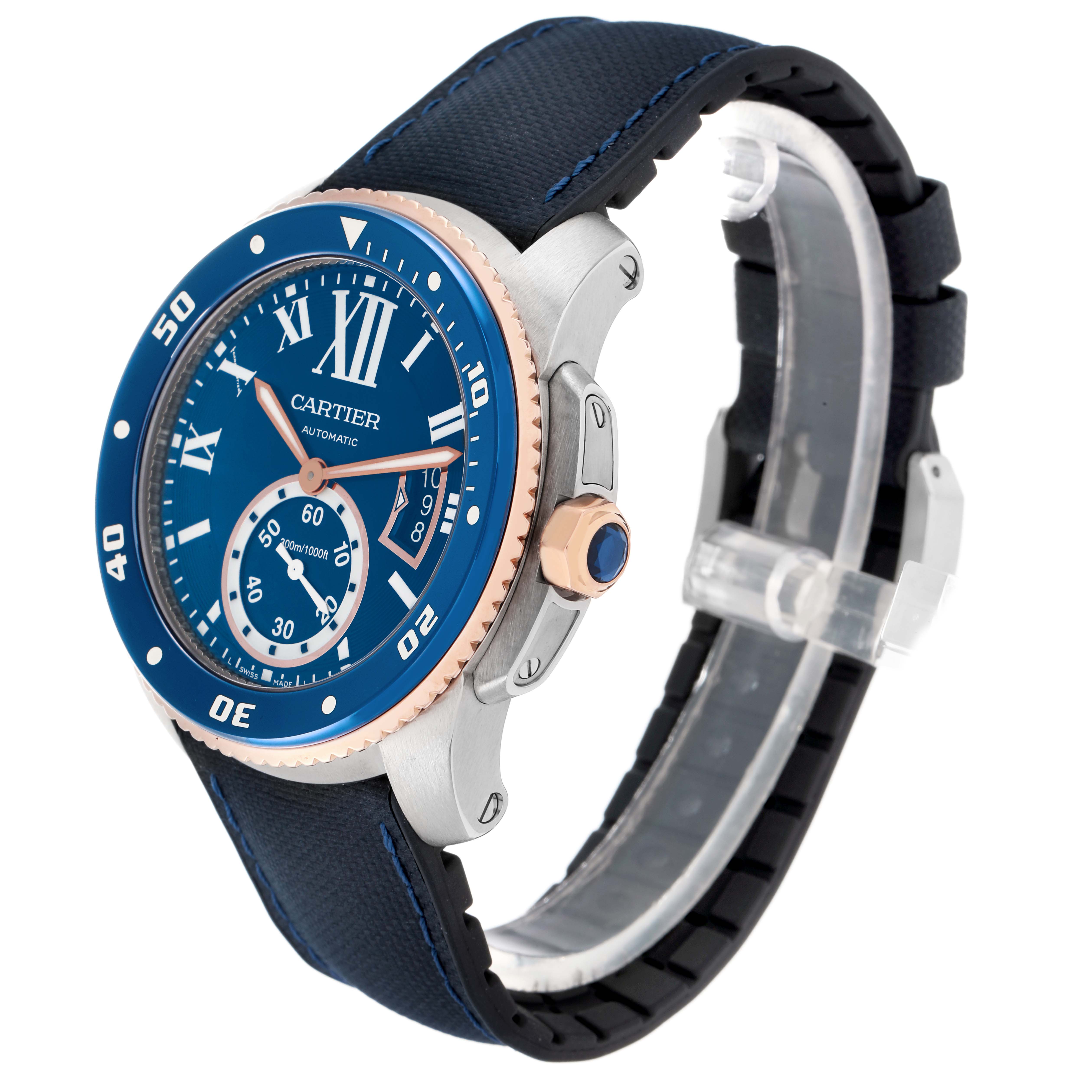 The Calibre de Cartier watch is shown at a three-quarter angle, highlighting its blue dial, bezel, crown, and strap.