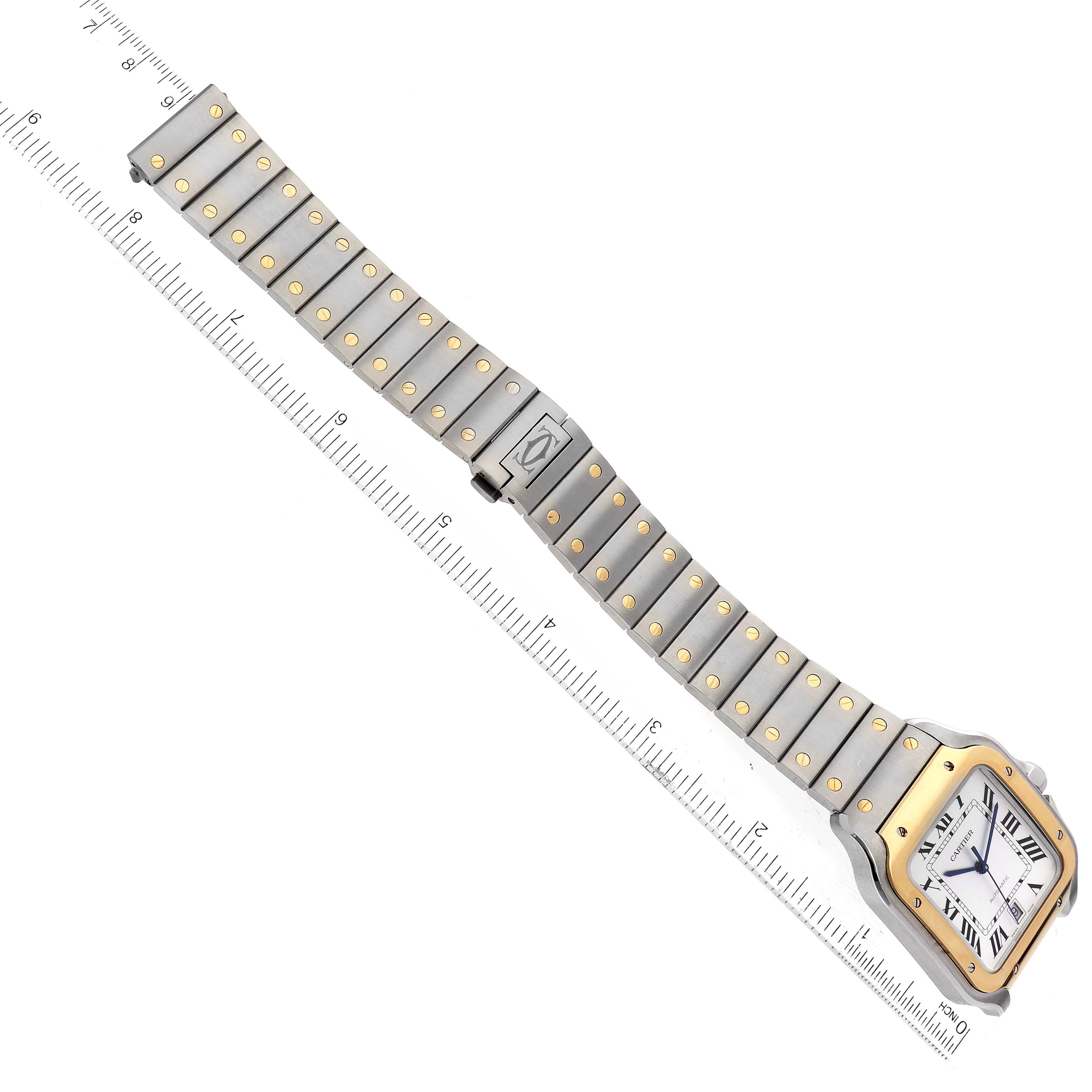 The image shows the entire Santos model watch by Cartier from an overhead angle, alongside a measuring ruler.