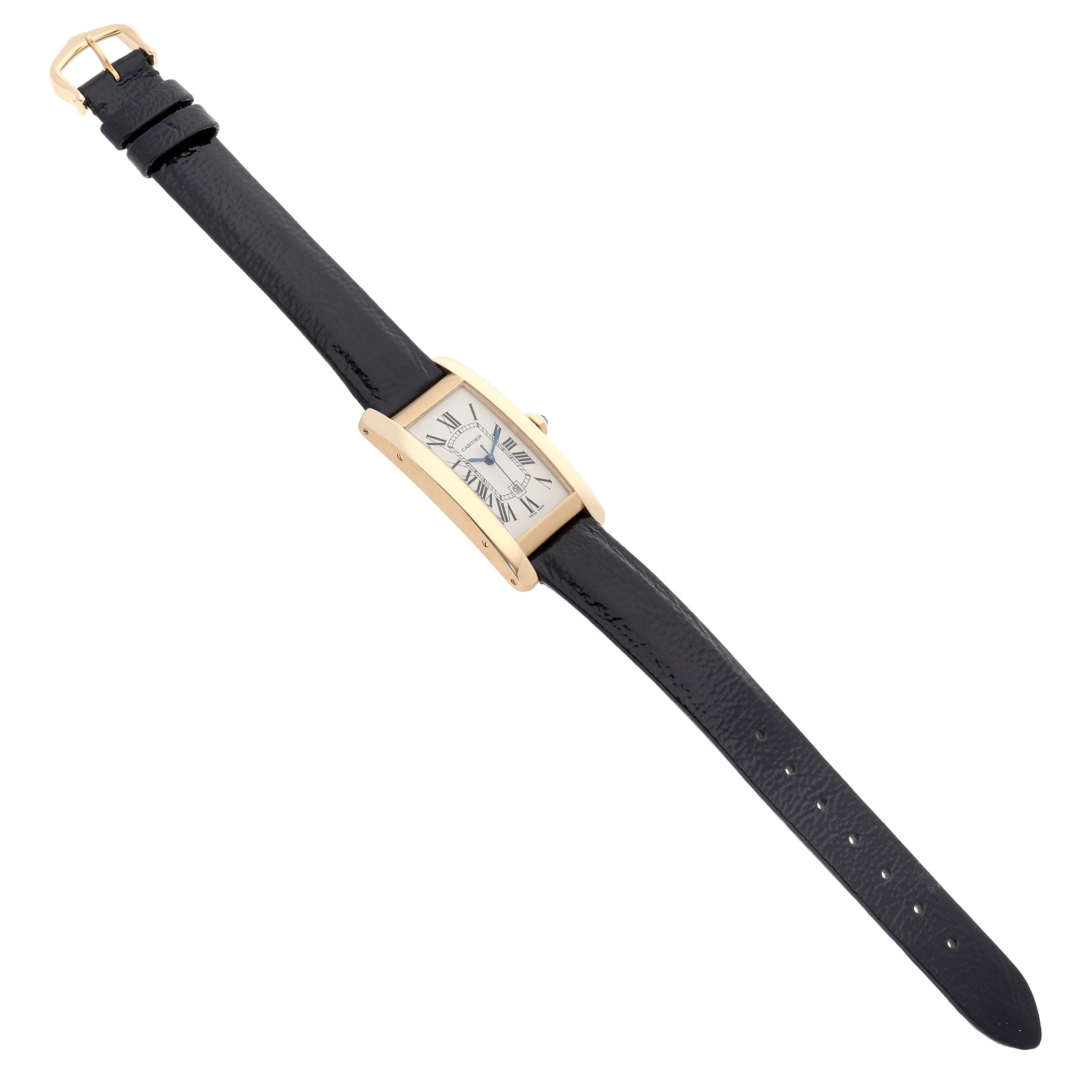 The Cartier Tank Americaine W2603556 Men's Yellow Gold Silver Dial watch is shown from a top angle, displaying its entire leather strap, rectangular case, and dial.